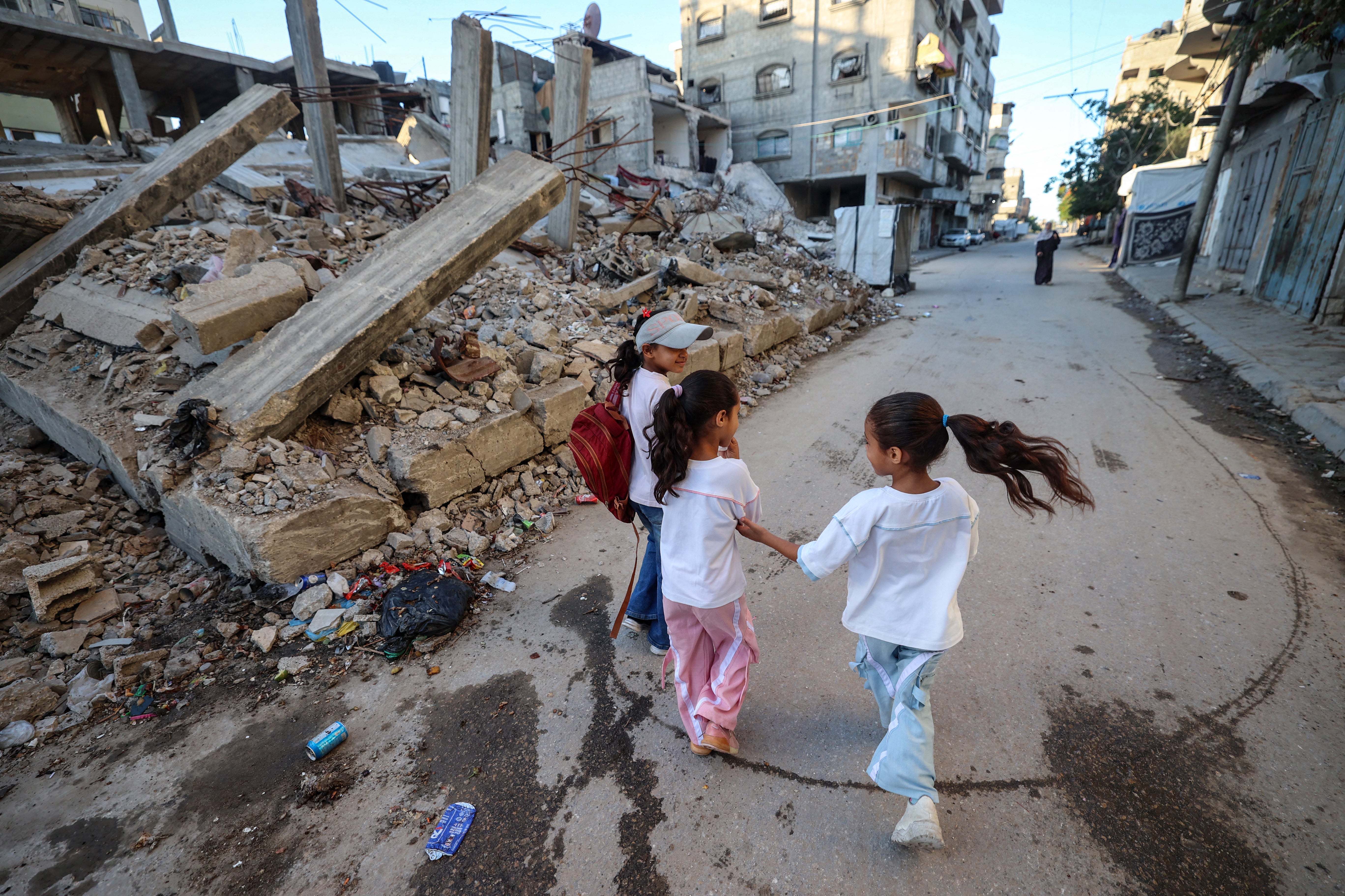 Palestinian children are seen here walking to school through the destroyed neighbourhood of Bureij in the central Gaza strip