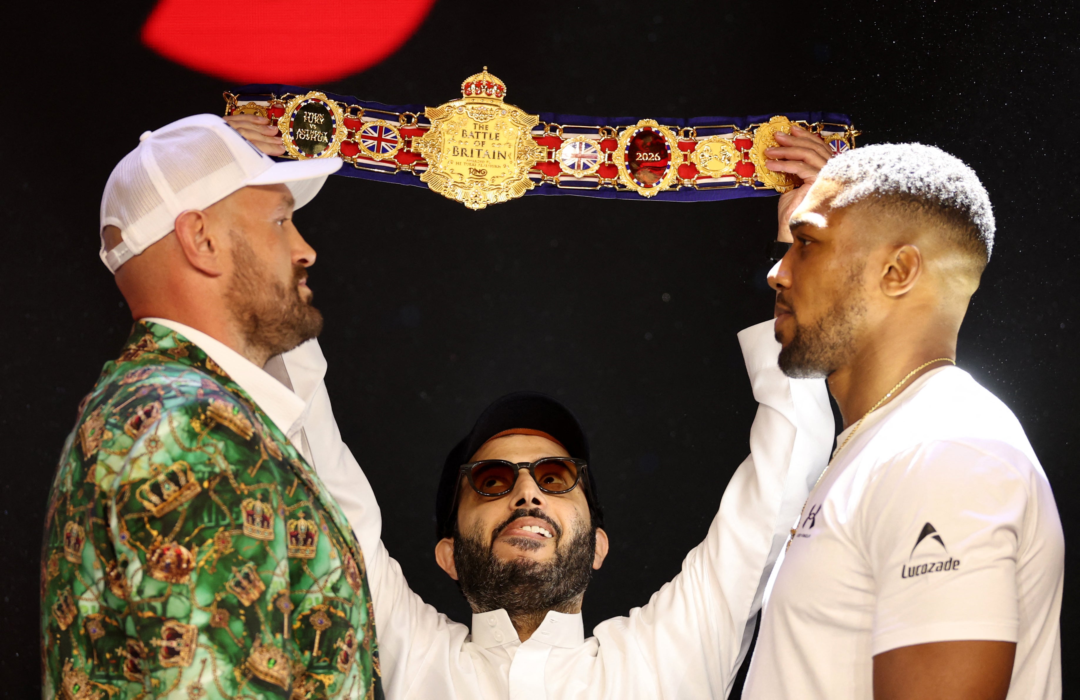 Turki Alalshikh (centre) holds up the belt during Anthony Joshua (right) and Tyson Fury's face off