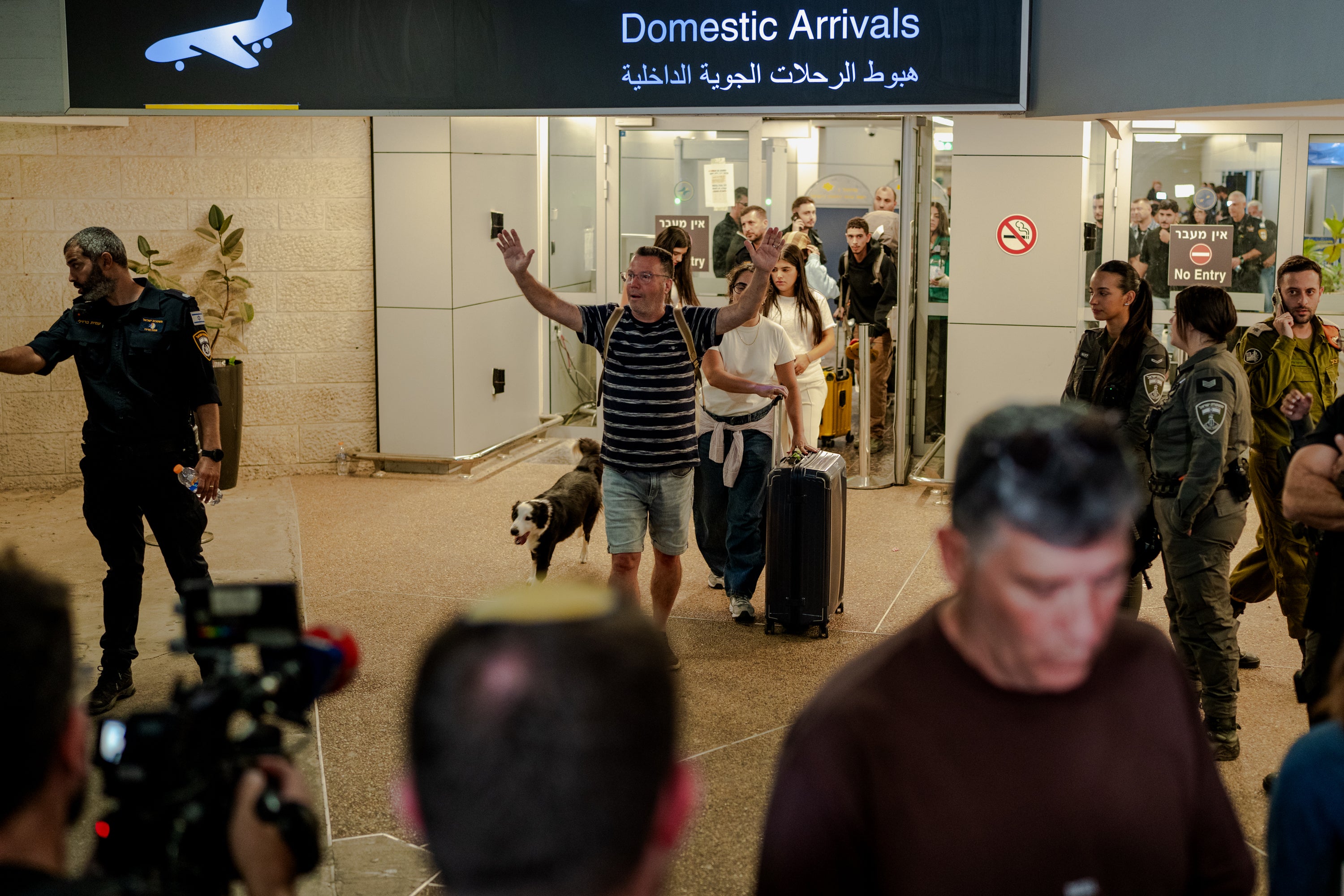 A passenger raises his arms in relief as he arrives in Ben Gurion Airport on Wednesday, after the Flydubai flight to Tel Aviv had to be diverted