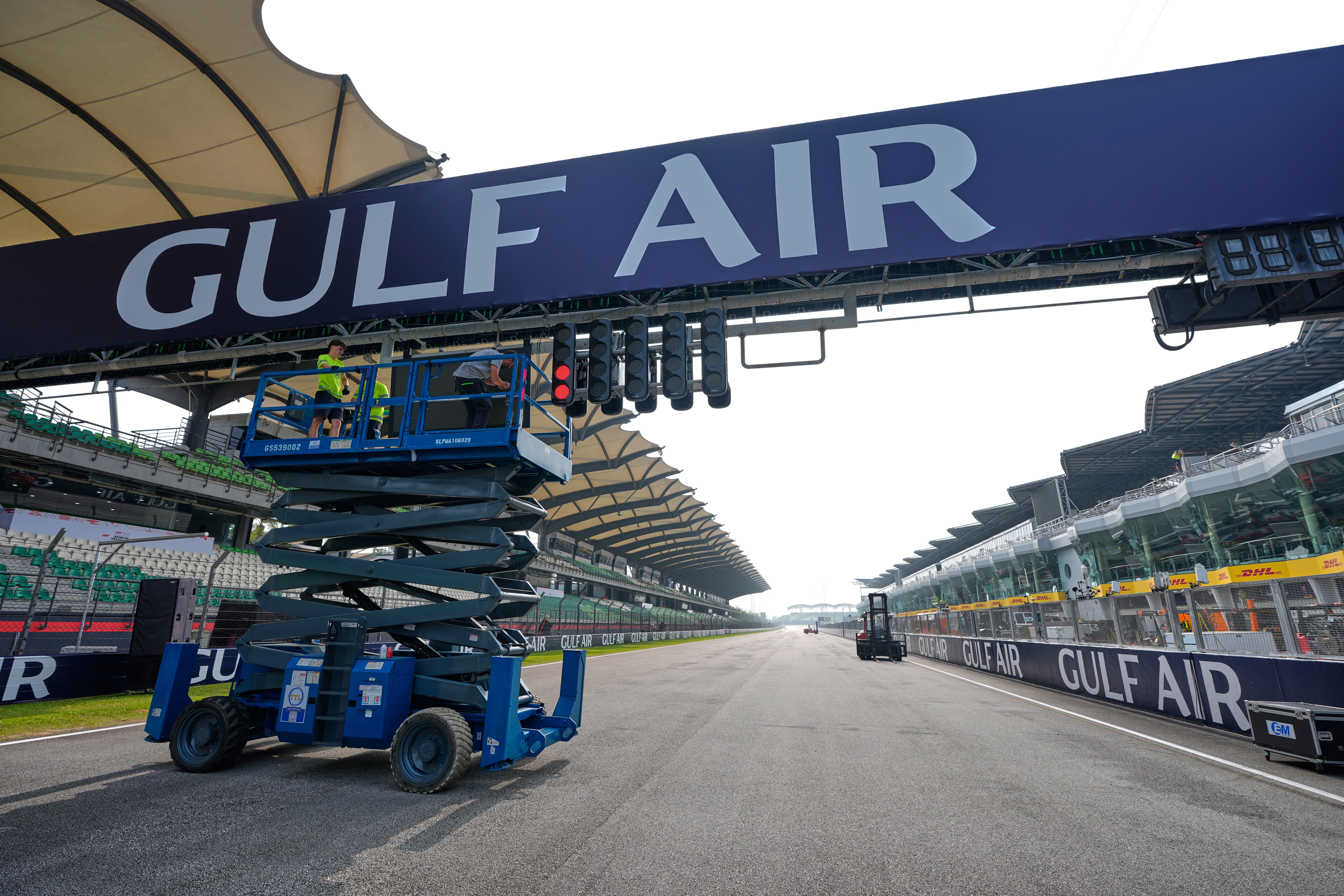 A Gulf Air banner is installed above the starting grid at the Sepang circuit (AP)
