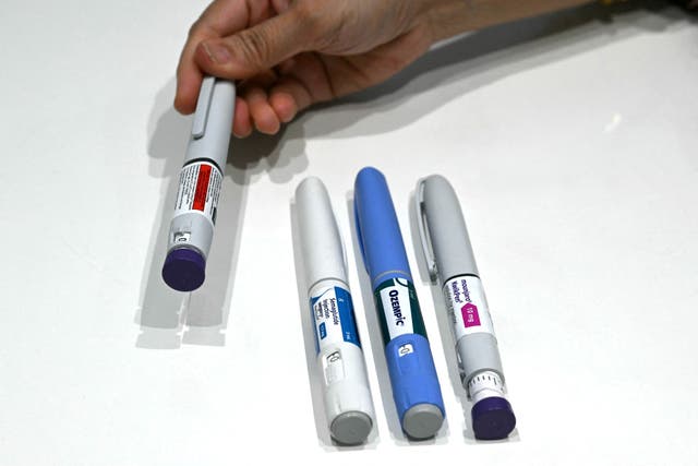 This photograph taken on March 17, 2026 shows obesity doctor and consultant Swati Pradhan showing various GLP-1 self-injectable devices at her clinic in Mumbai.