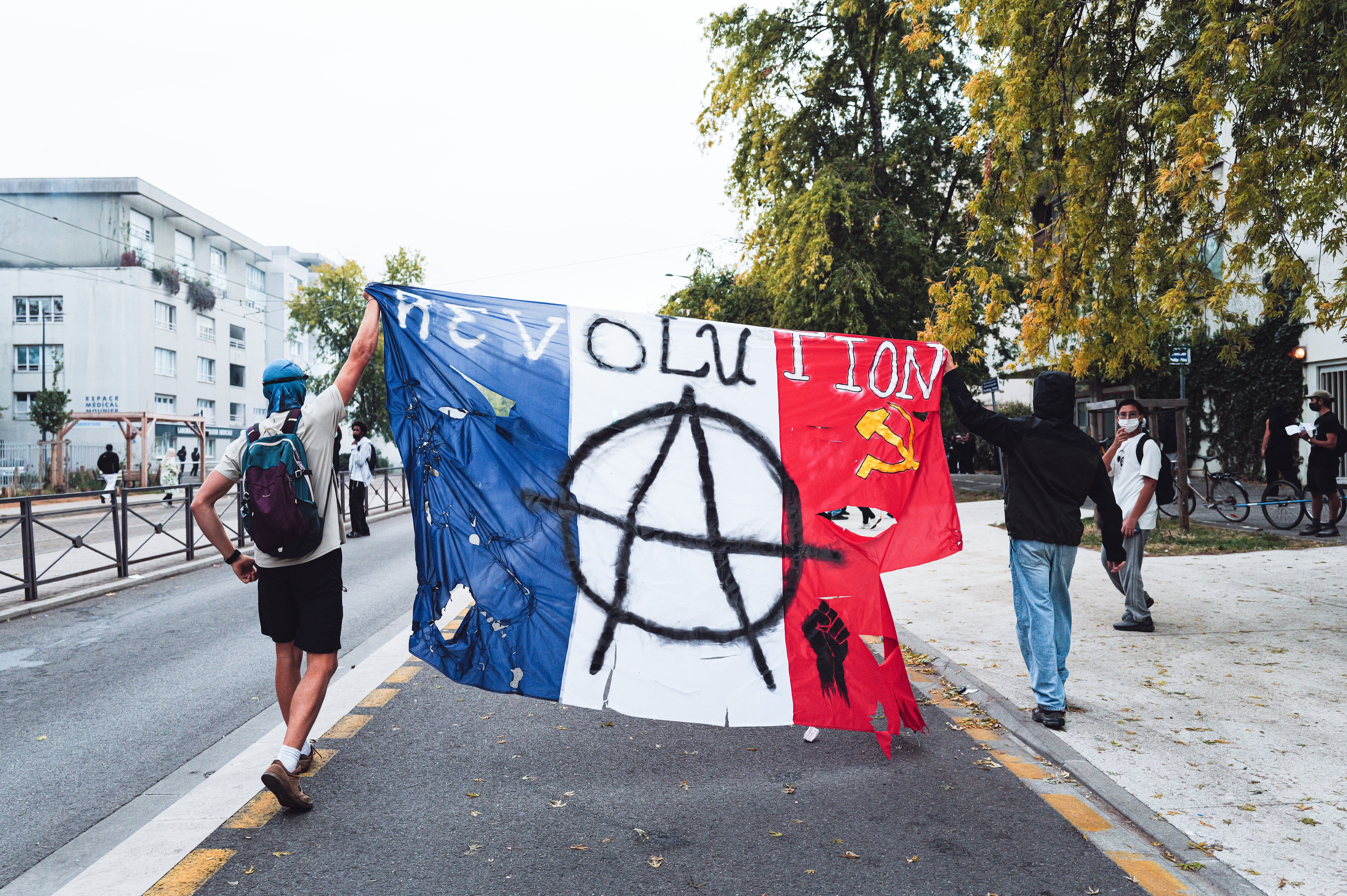 Two secondary school pupils are holding aloft a French flag bearing the word REVOLUTION on Thursday 1 October 2026 during the blockade of the Mounier secondary school in Grenoble