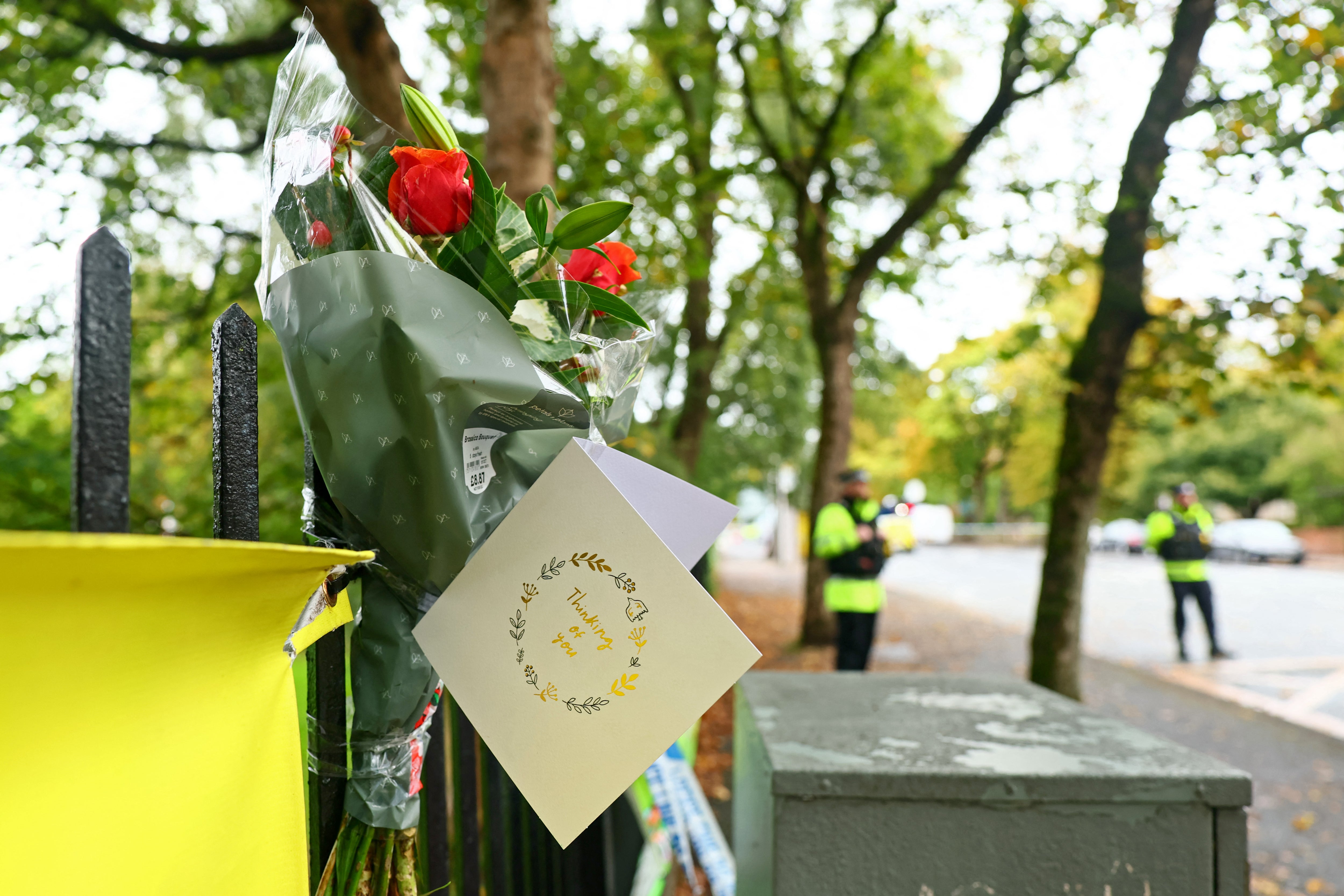 Flowers and messages of condolence are pictured by a Police cordon on the main road outside Heaton Park Hebrew Congregation synagogue