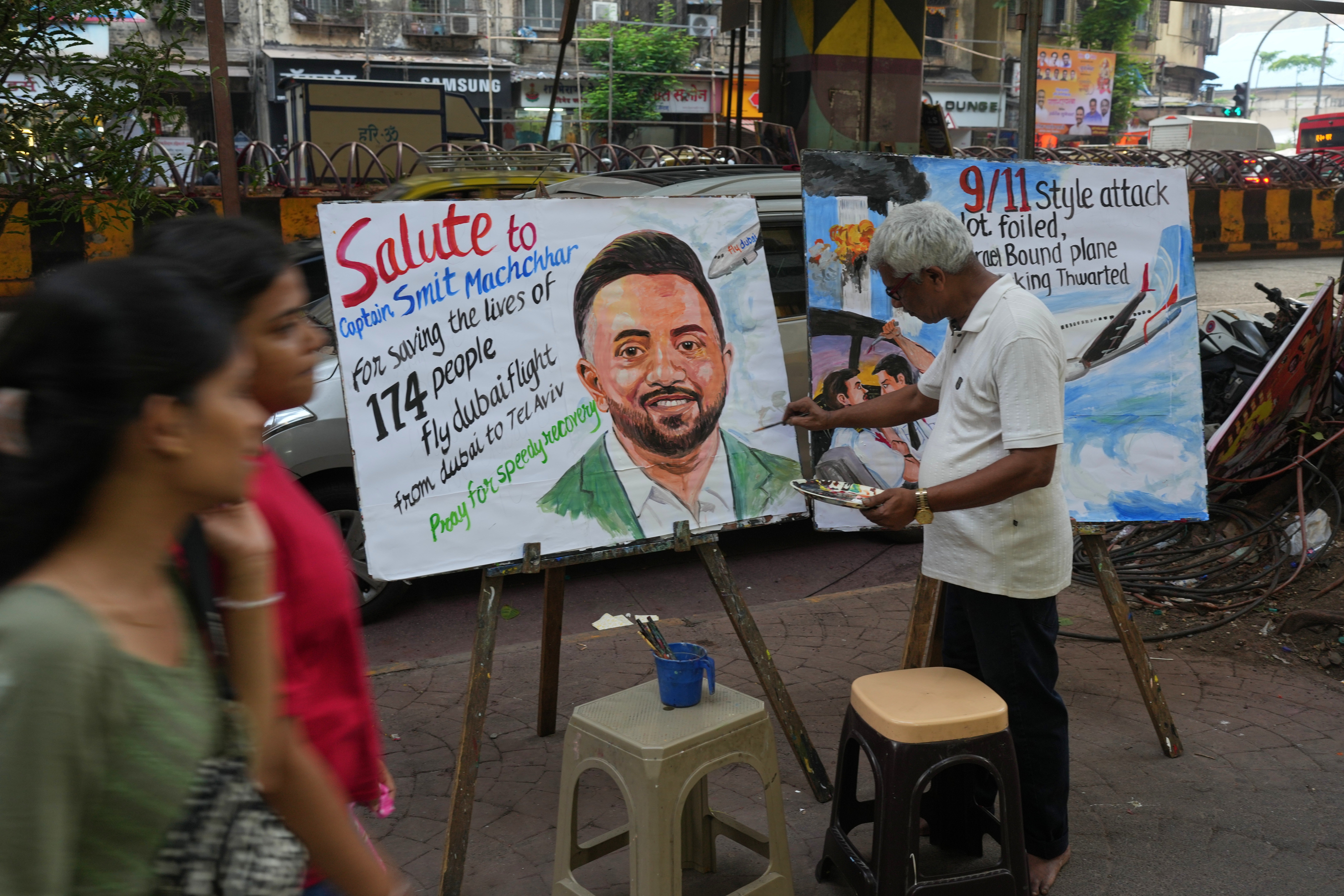 A teacher from Gurukul School of Art paints a portrait honoring Smit Machchhar,, an Indian pilot with FlyDubai, in Mumbai, India, Thursday, Oct. 1, 2026.(AP Photo/Rafiq Maqbool)
