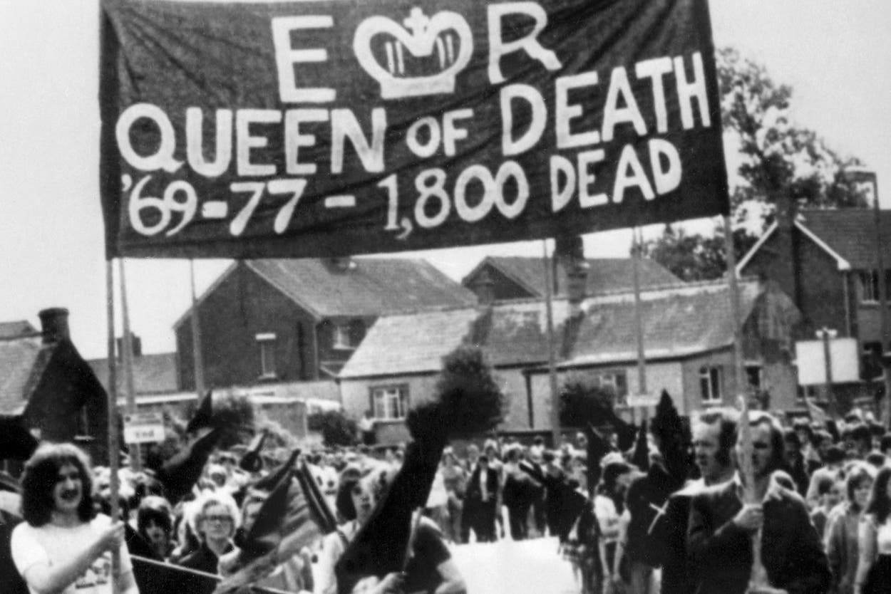 Members of the Provisional Irish Republican Army (IRA) hold a banner reading
