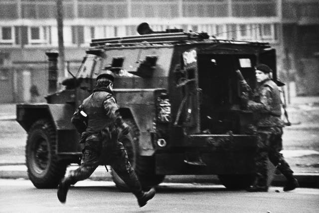 British soldiers caught under IRA fire run for cover inside their armoured car in Londonderry, northern Ireland in 1988