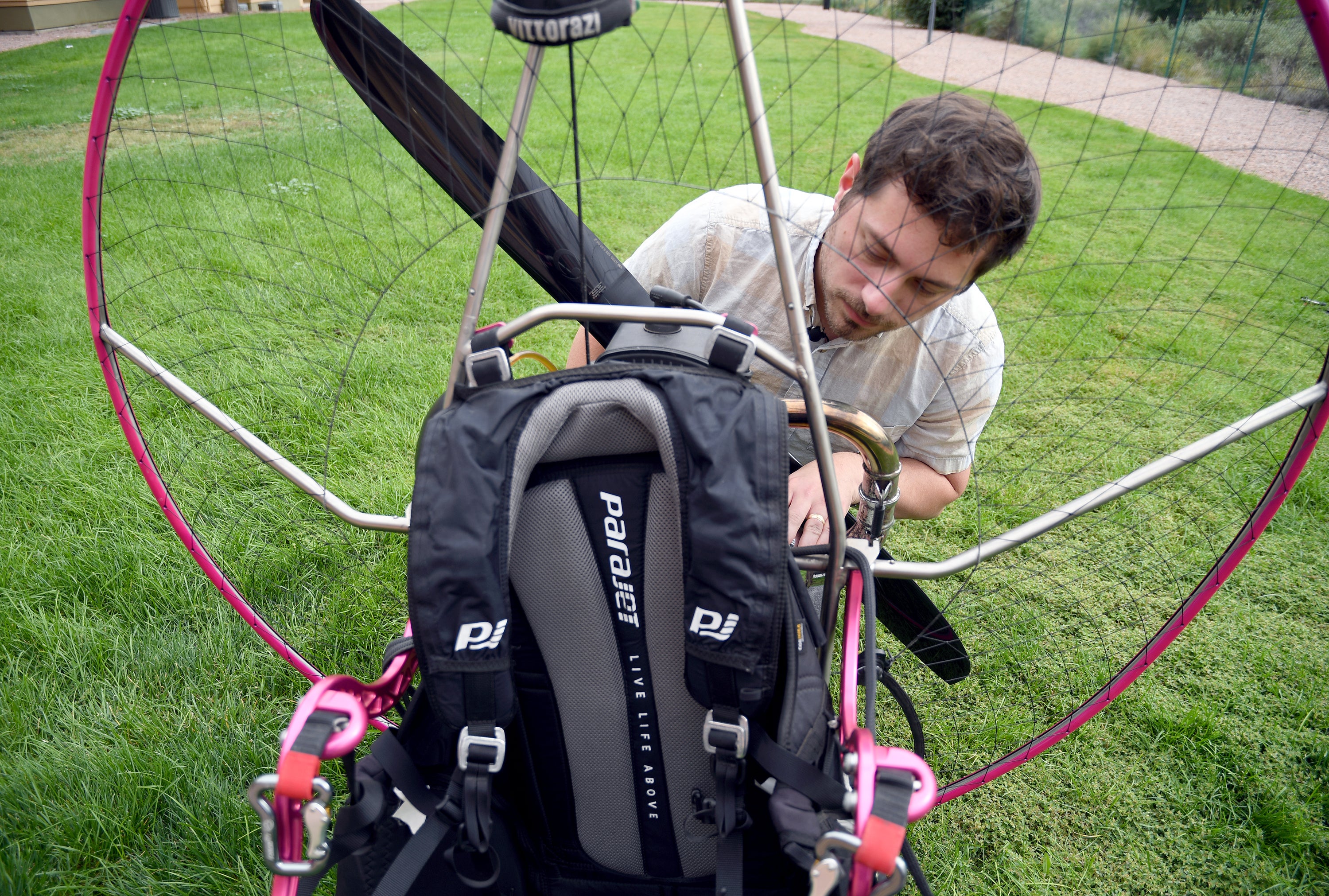 Jake Hutzler, who often flies to his air traffic controller job, inspects his paramotor outside his home in Pueblo, Colo., on Thursday, Oct. 1, 2026. (AP Photo/Thomas Peipert)