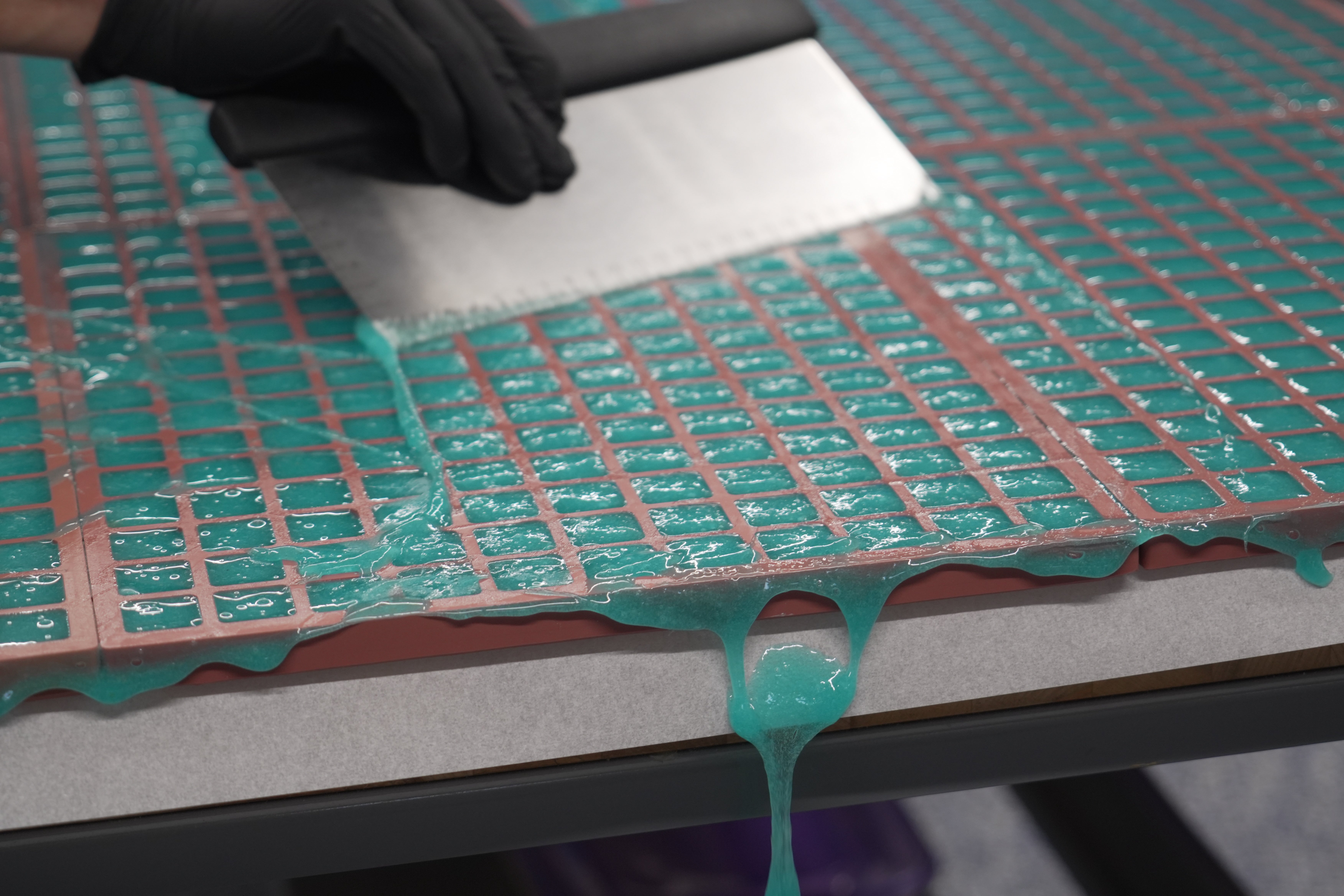 Hot gummy mixture drips off the table's edge as Nicholas Hohns uses a pastry knife to fill mold at his Deutermann Farms kitchen in Clayton, N.C., on Wednesday, Sept. 23, 2026. (AP Photo/Allen G. Breed)