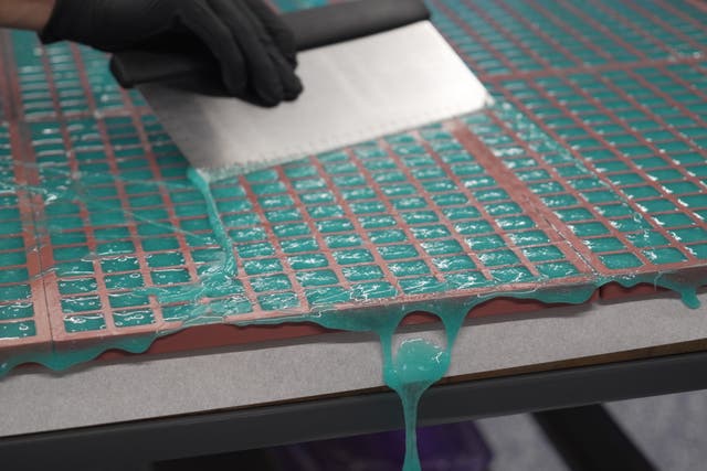 Hot gummy mixture drips off the table's edge as Nicholas Hohns uses a pastry knife to fill mold at his Deutermann Farms kitchen in Clayton, N.C., on Wednesday, Sept. 23, 2026. (AP Photo/Allen G. Breed)