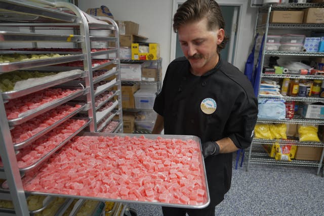 Nicholas Hohns shows off a tray of strawberry-lemon CBD gummies at his Deutermann Farms kitchen in Clayton, N.C., on Wednesday, Sept. 23, 2026. (AP Photo/Allen G. Breed)