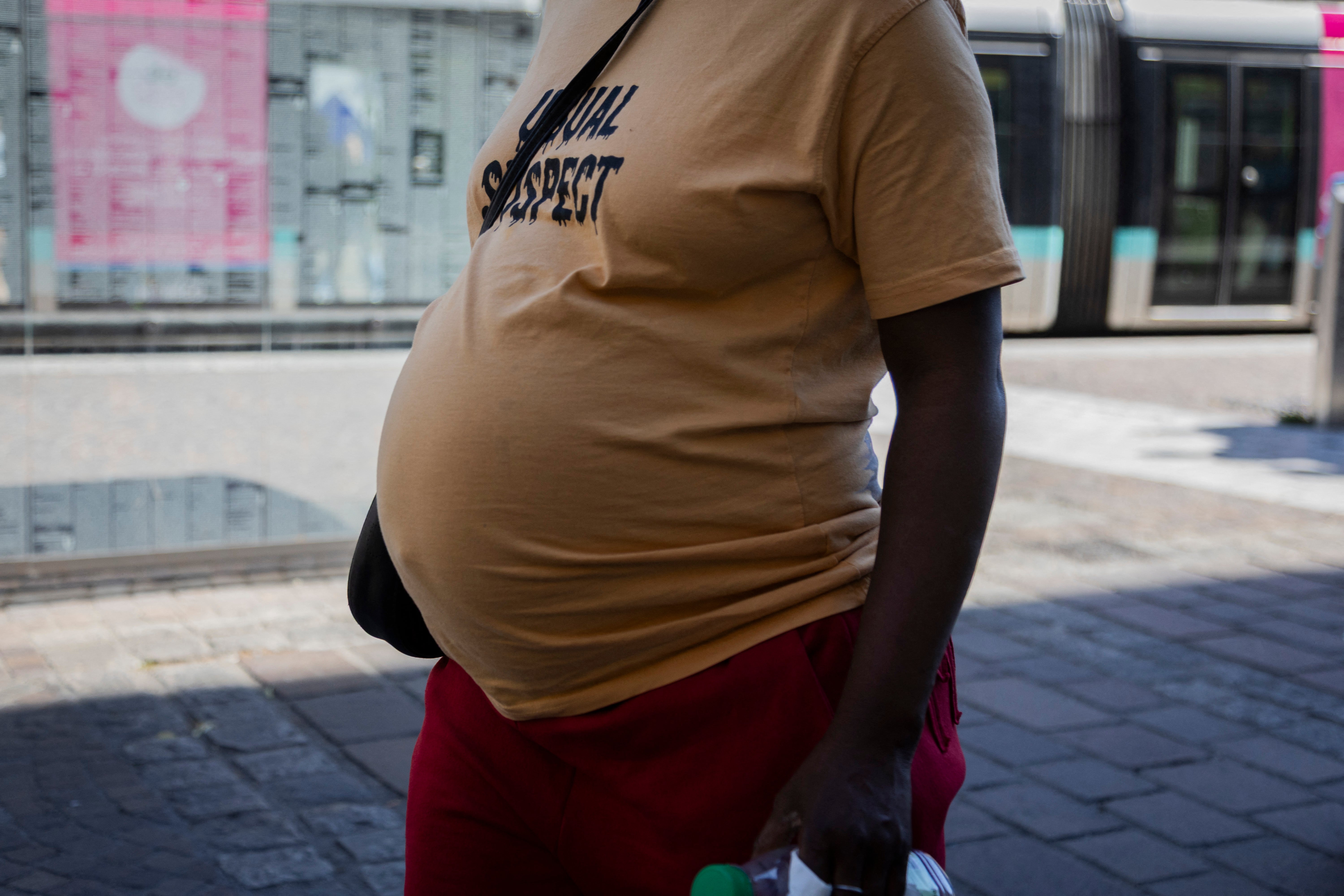 A pregnant woman walks through the French city of Grenoble during a heatwave in early July