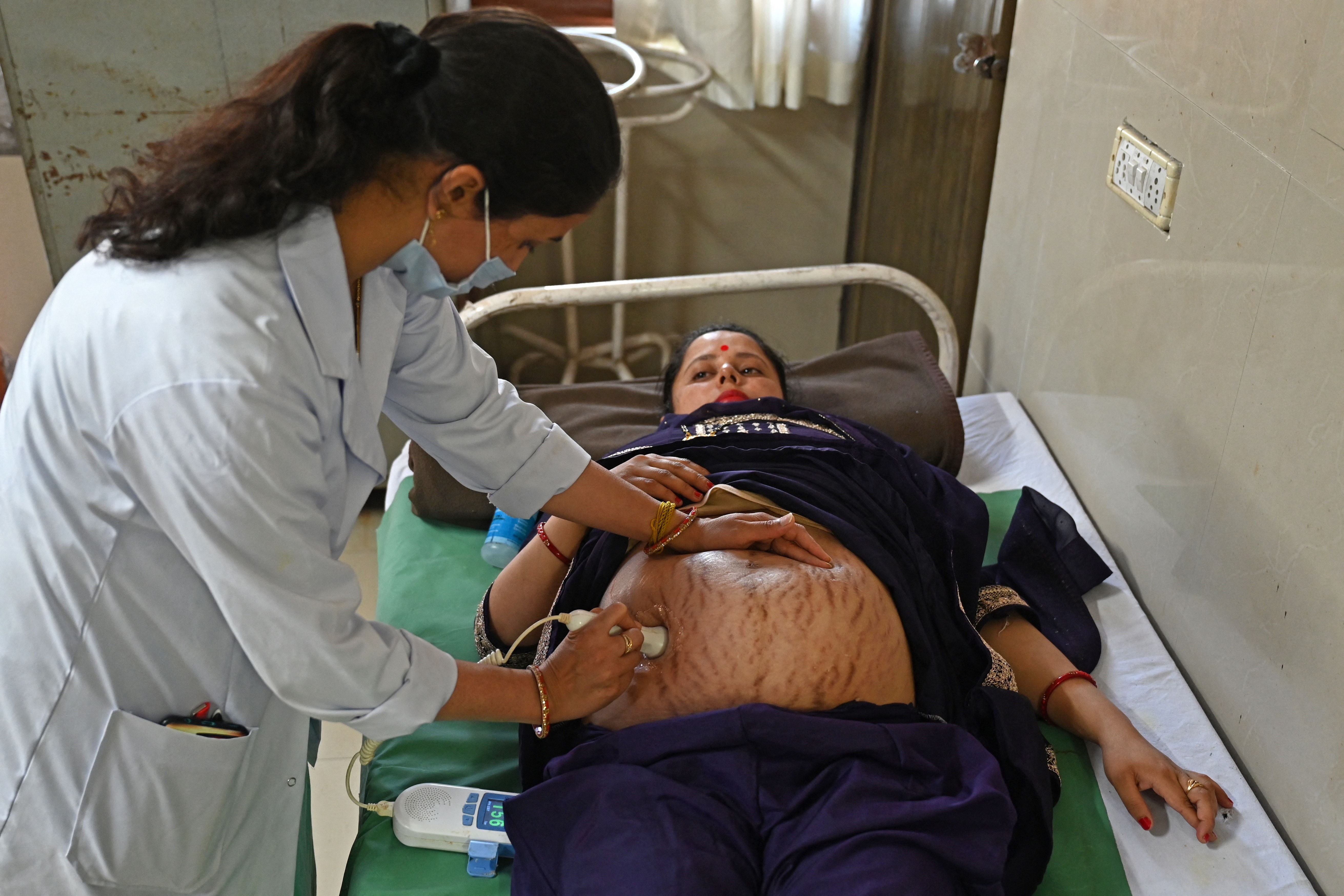 A pregnant woman is checked by a doctor at a hospital in Dehra, in the Kangra district of India's Himachal Pradesh state