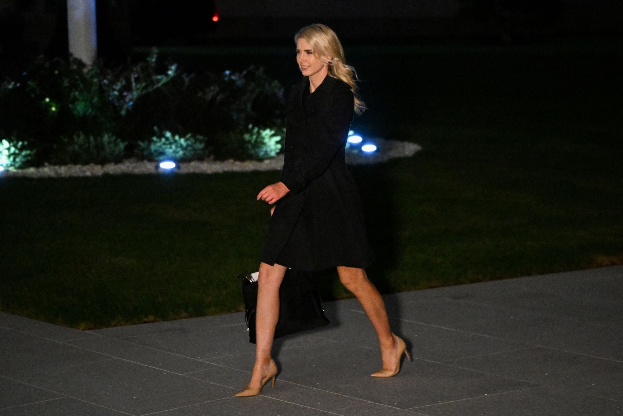 Question have been raised about Harp's proximity to President Donald Trump as she is often seen traveling with him (AFP via Getty Images)