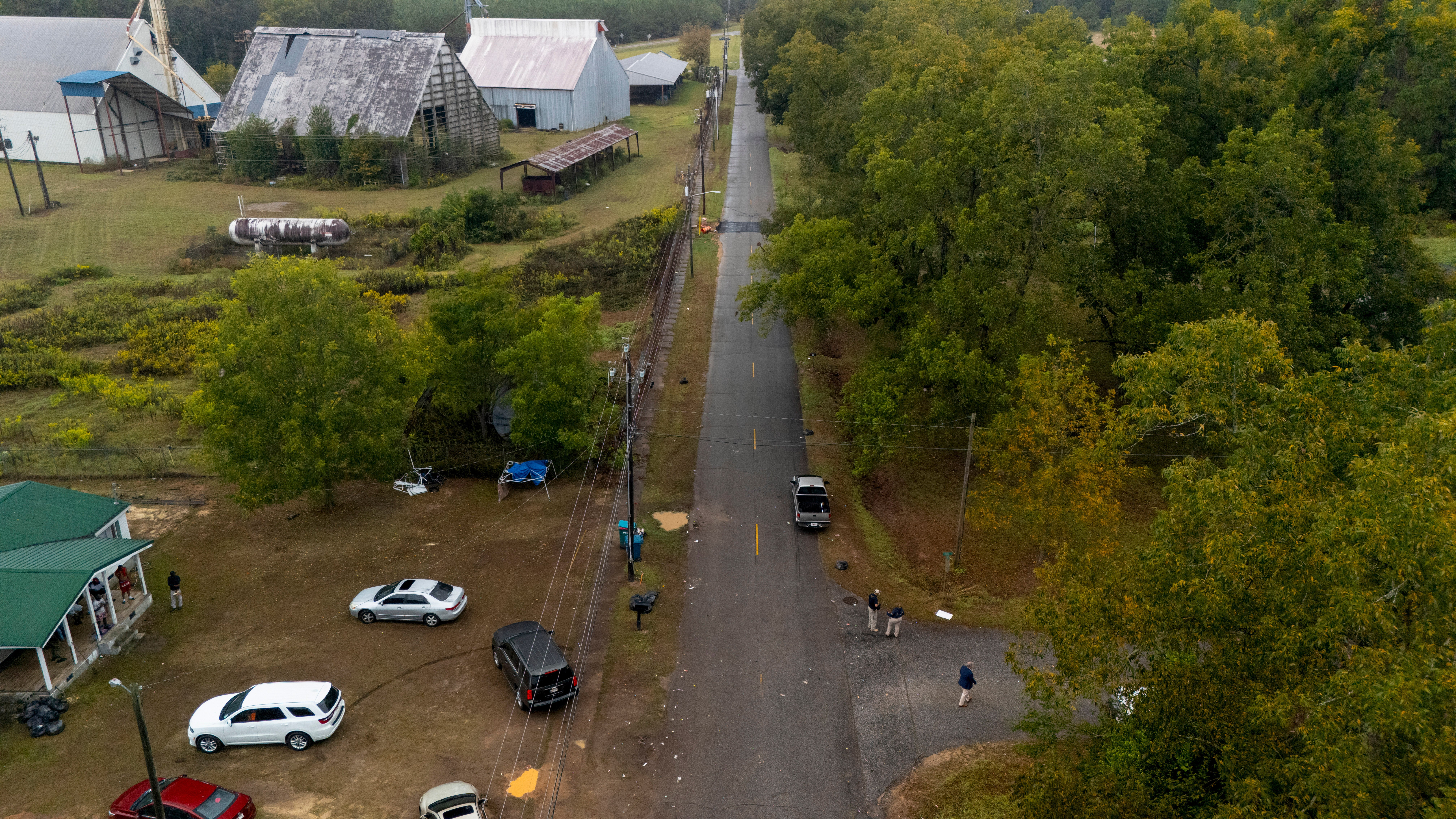 Authorities, below to the right, investigate the scene of a mass shooting where at least two people died and 35 were injured when struck by bullets Sunday morning, according to the Georgia Bureau of Investigation, Sunday, Oct. 4, 2026, in Vienna, Ga. (AP Photo/Mike Stewart)