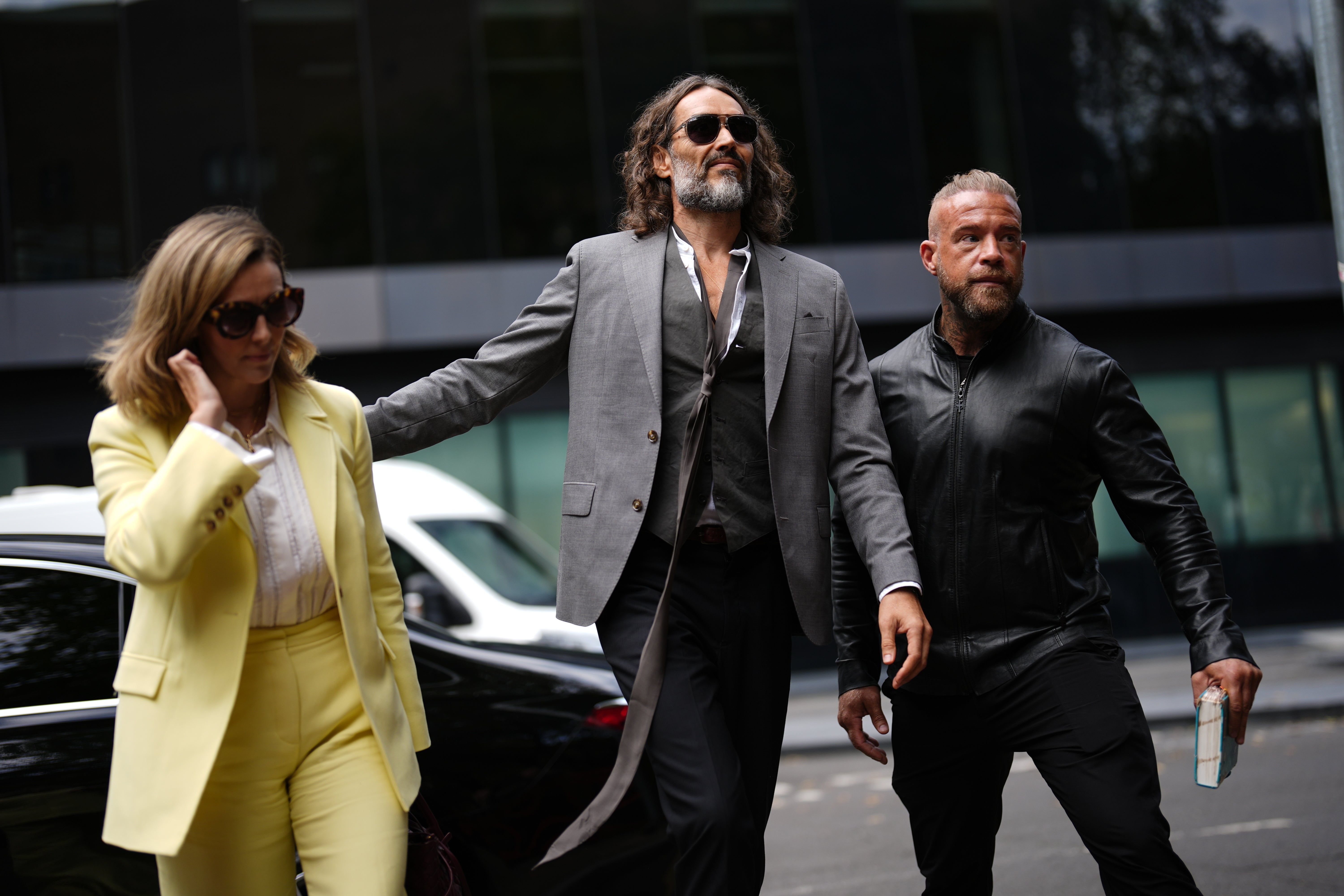 Russell Brand was accompanied by his wife Laura Gallacher and a security guard holding a Bible as he arrived at court last week