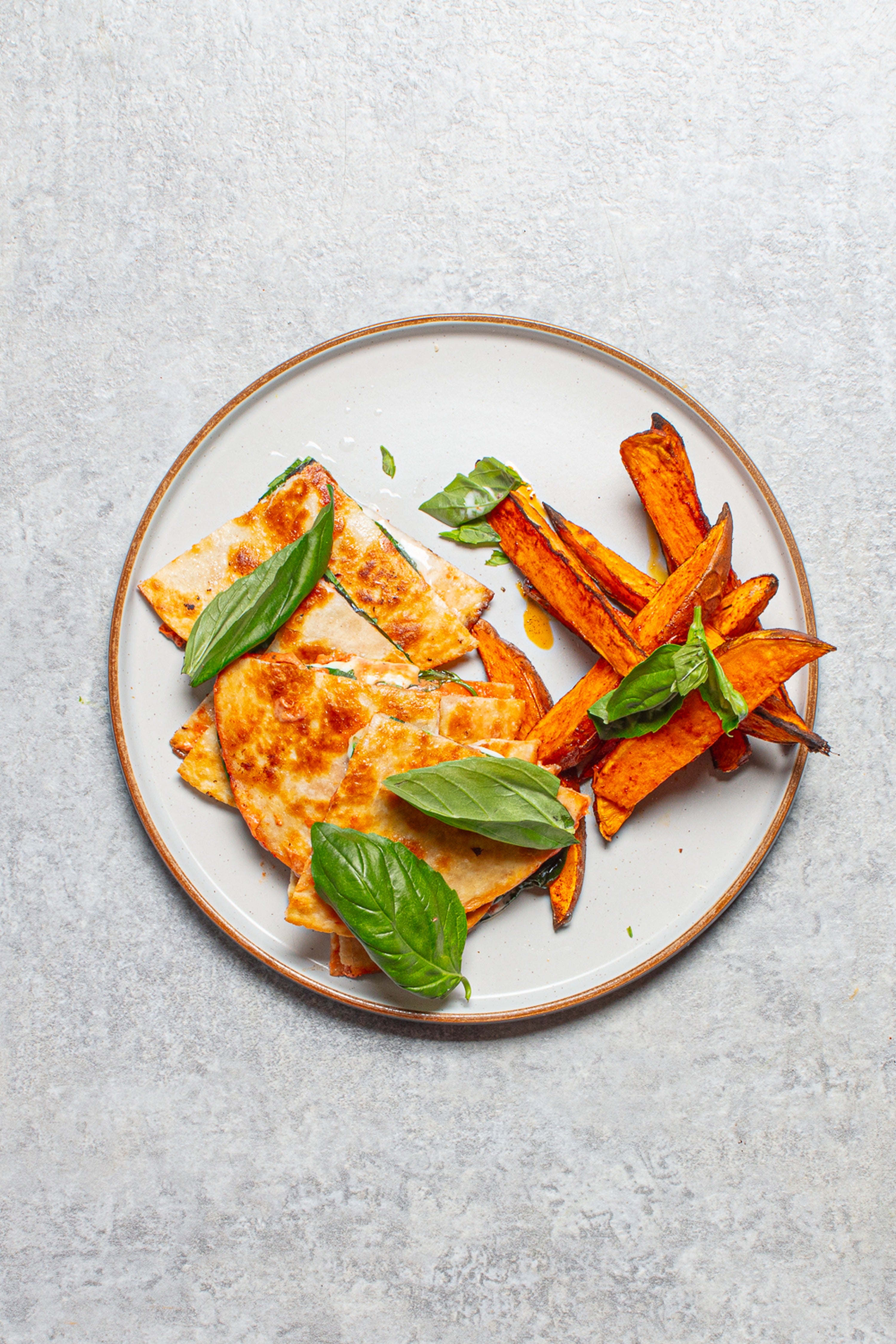 Crisp, cheesy pizzadillas with smoky sweet potato wedges and fresh basil
