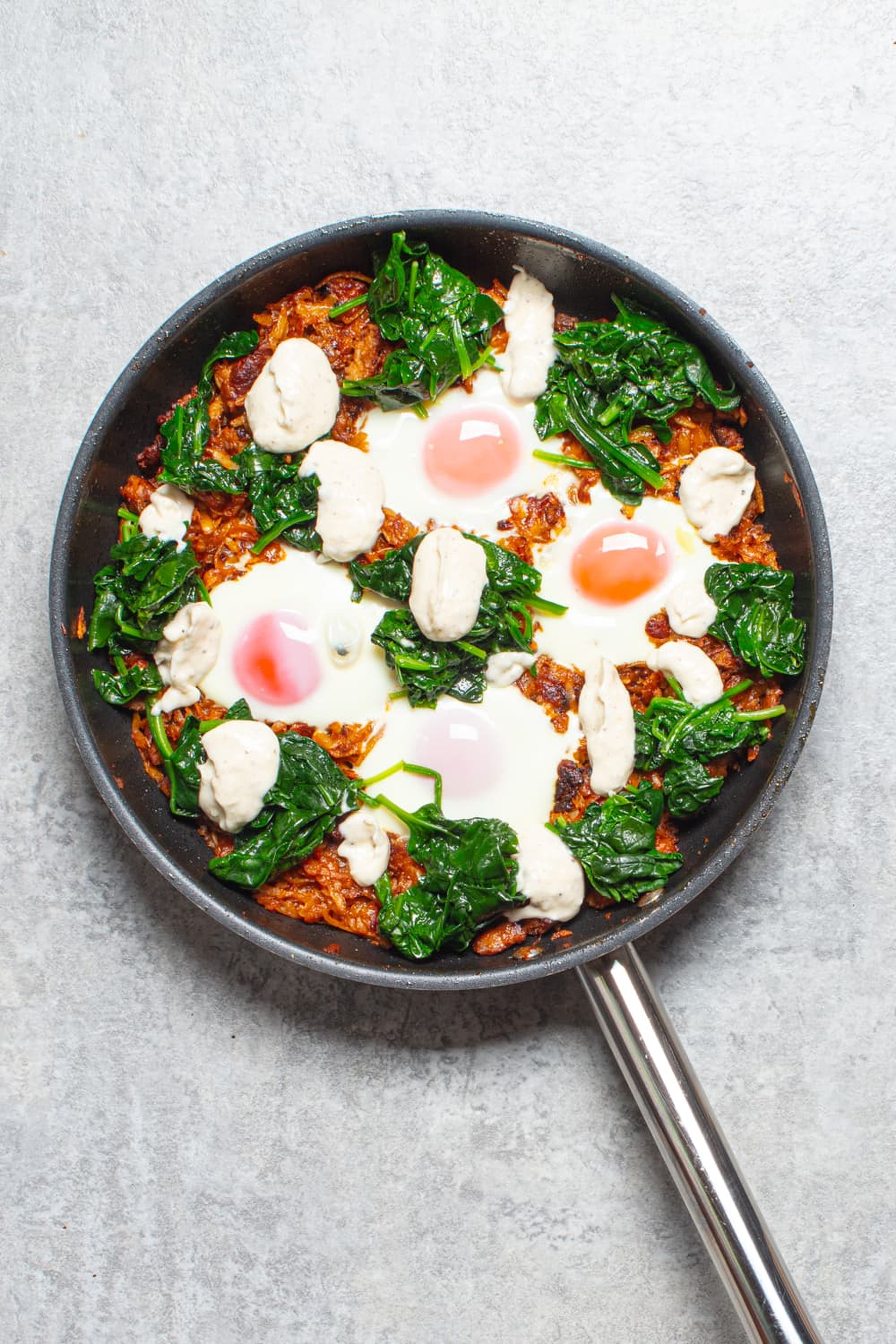 Crisp potato and sausage hash topped with baked eggs, wilted spinach and garlicky aioli