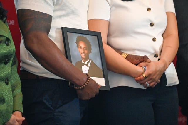 Christine Wonsley and Elmore Wonsley, mother and stepfather of Nolan Wells, stand on a stage with a portrait of their son as they appear at the National Urban League's annual conference