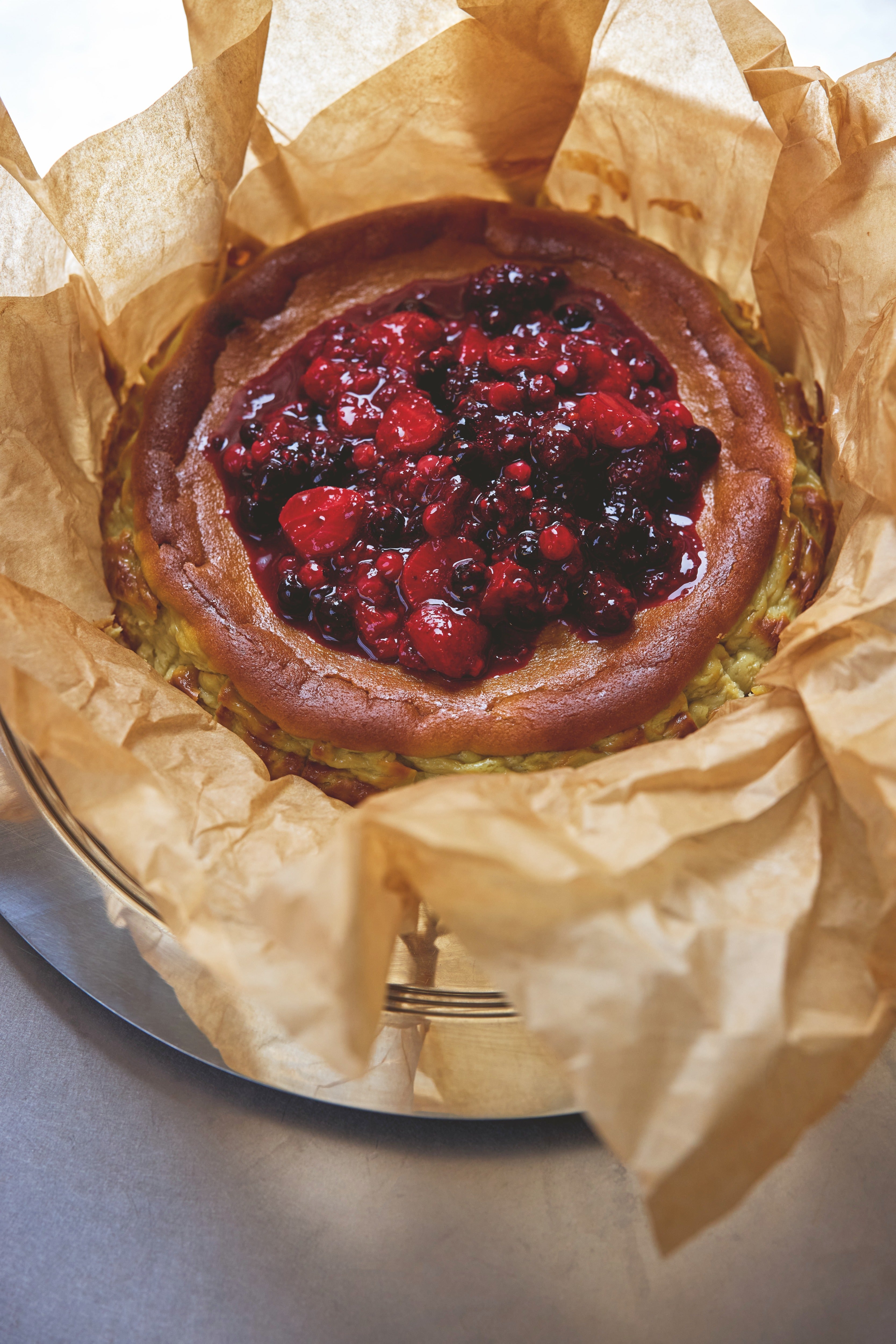 Bhogal’s pistachio Basque cheesecake is served with a roasted berry compote
