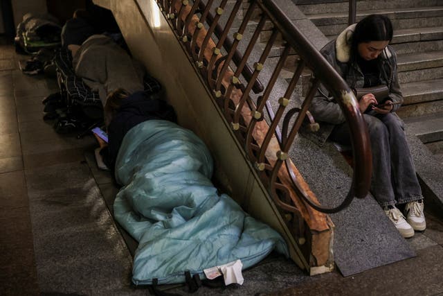 People take shelter inside a metro station during a Russian missile strike in Kyiv