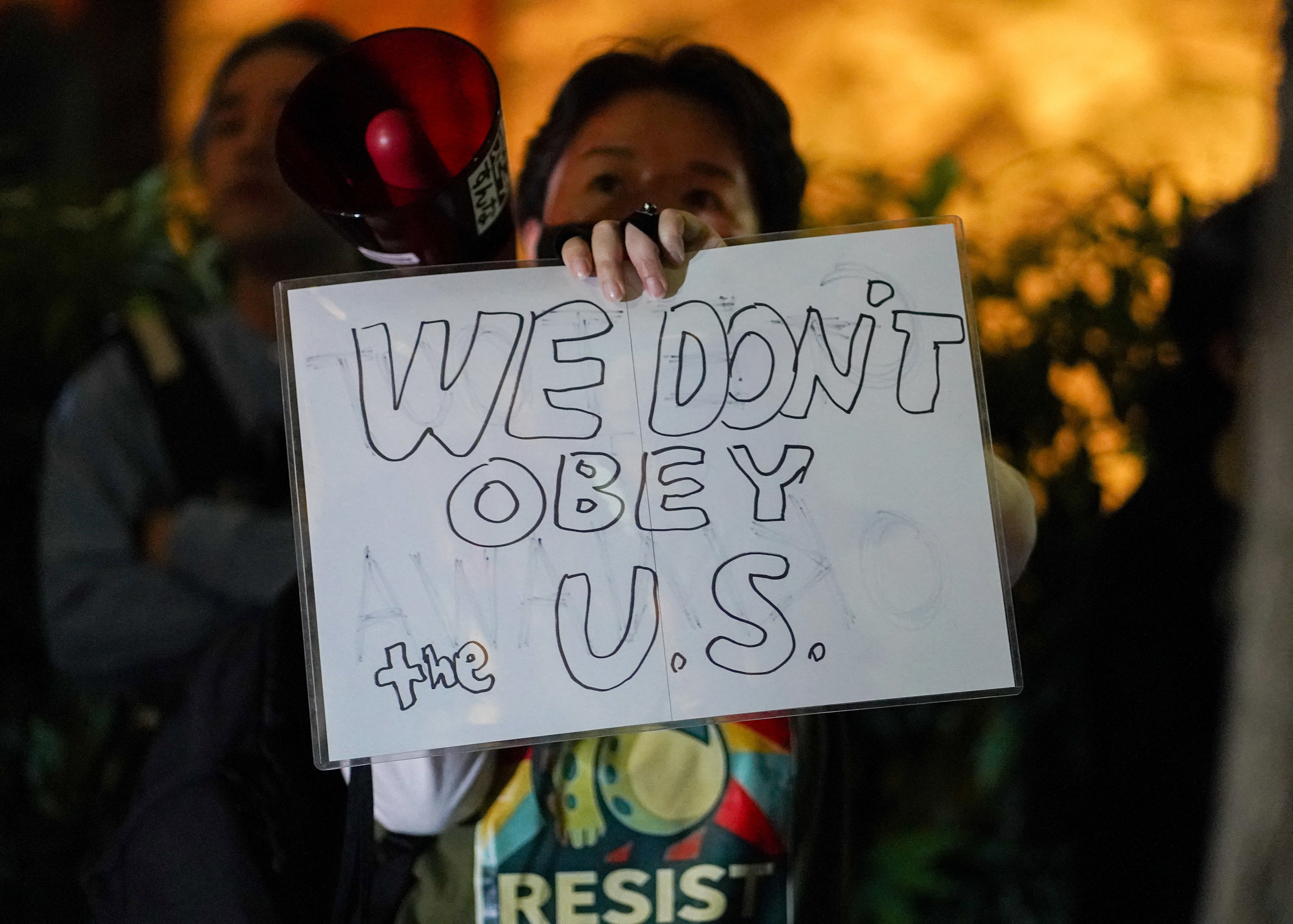 A demonstrator holds a sign during a protest against the murder, allegedly by a US Marine, of a woman in Okinawa in front of the American embassy in Tokyo on 6 October 2026