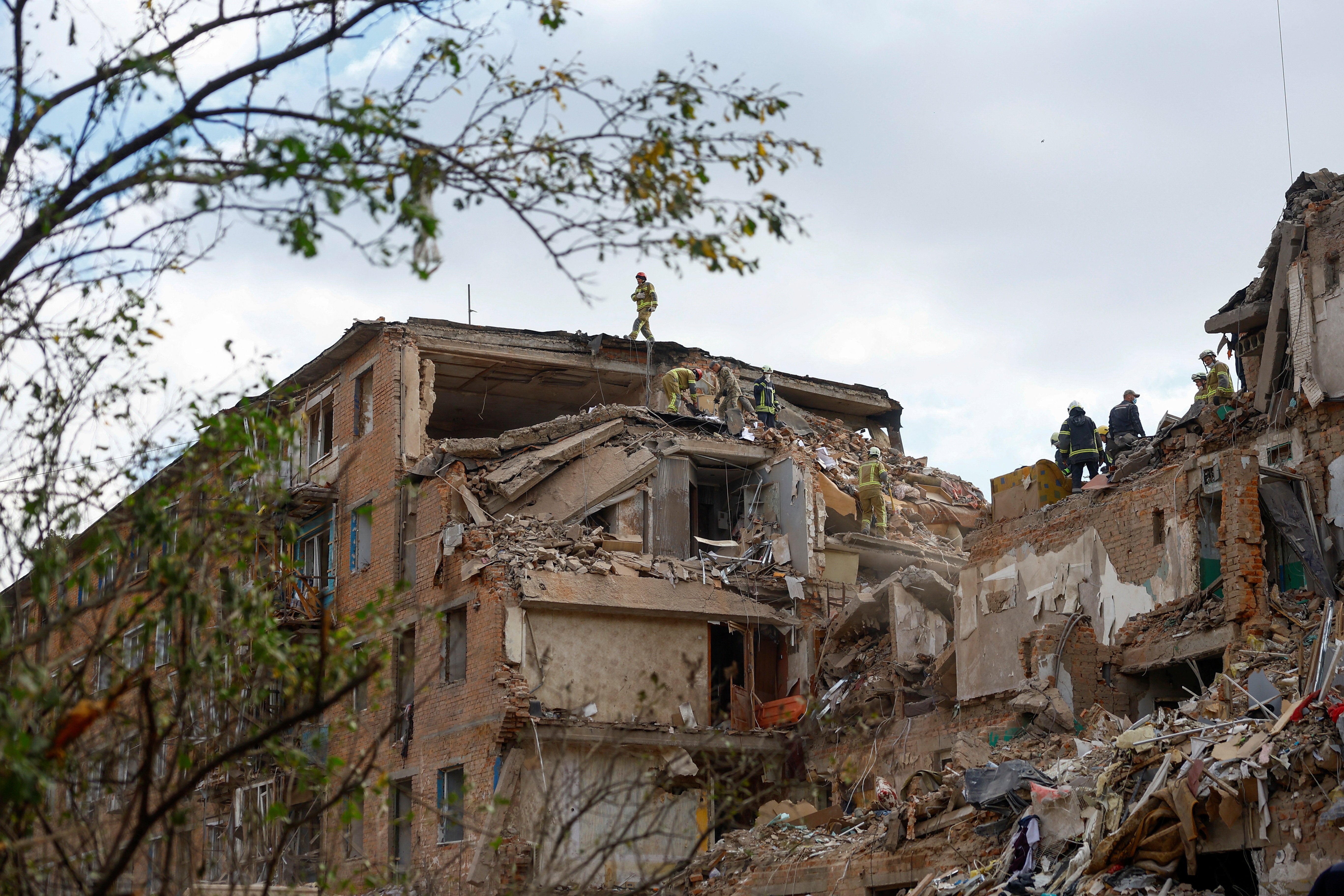 Rescuers work at the site of an apartment building which was hit by a Russian missile strike