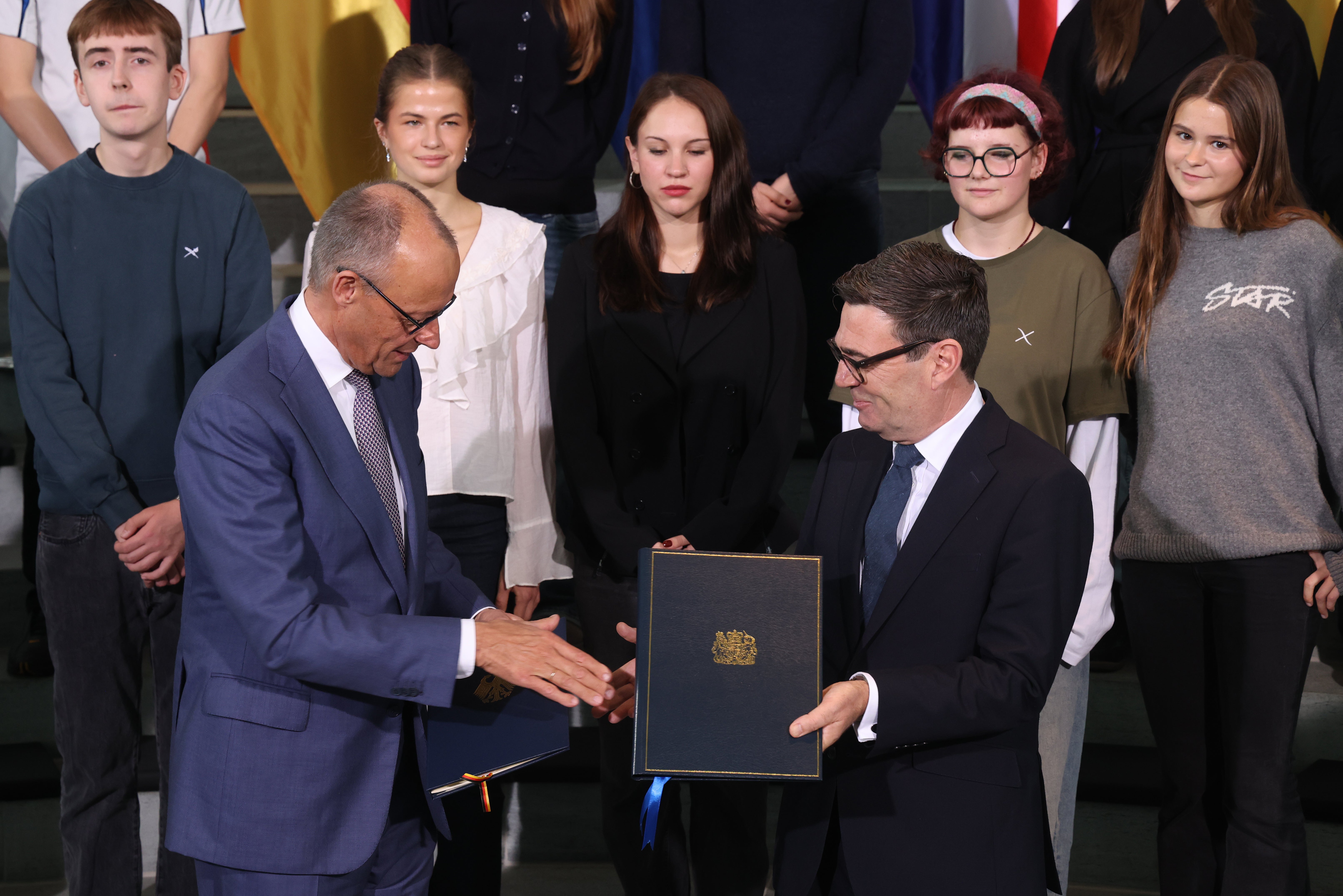 German Chancellor Friedrich Merz and British Prime Minister Andy Burnham exchange ratification documents of the Kensington Treaty