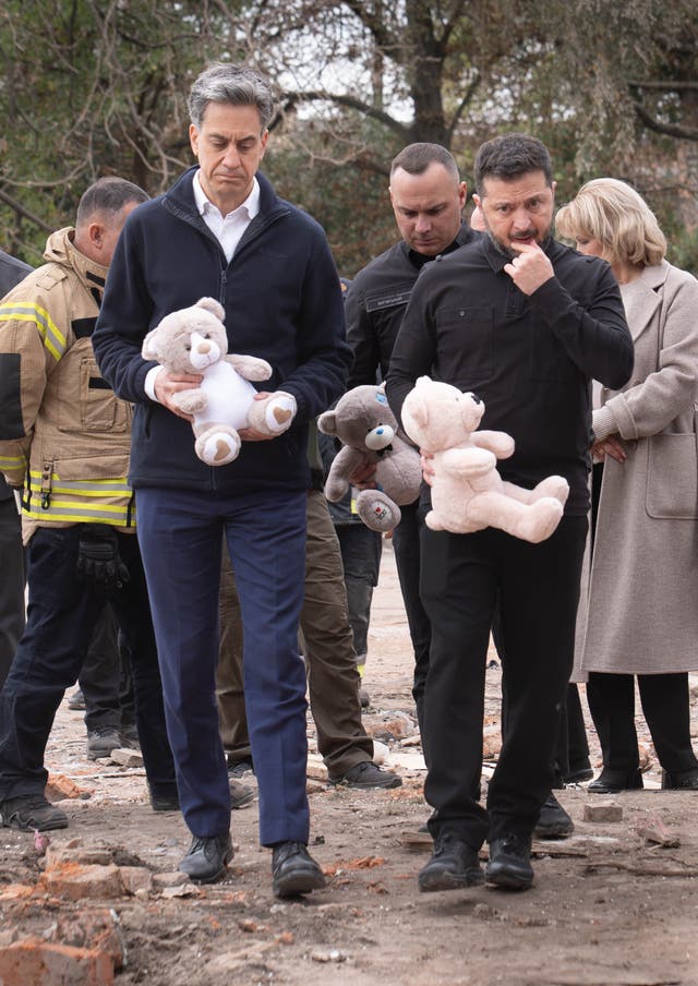 Miliband (left) and Zelensky left bears at the site of the attack, which killed five children
