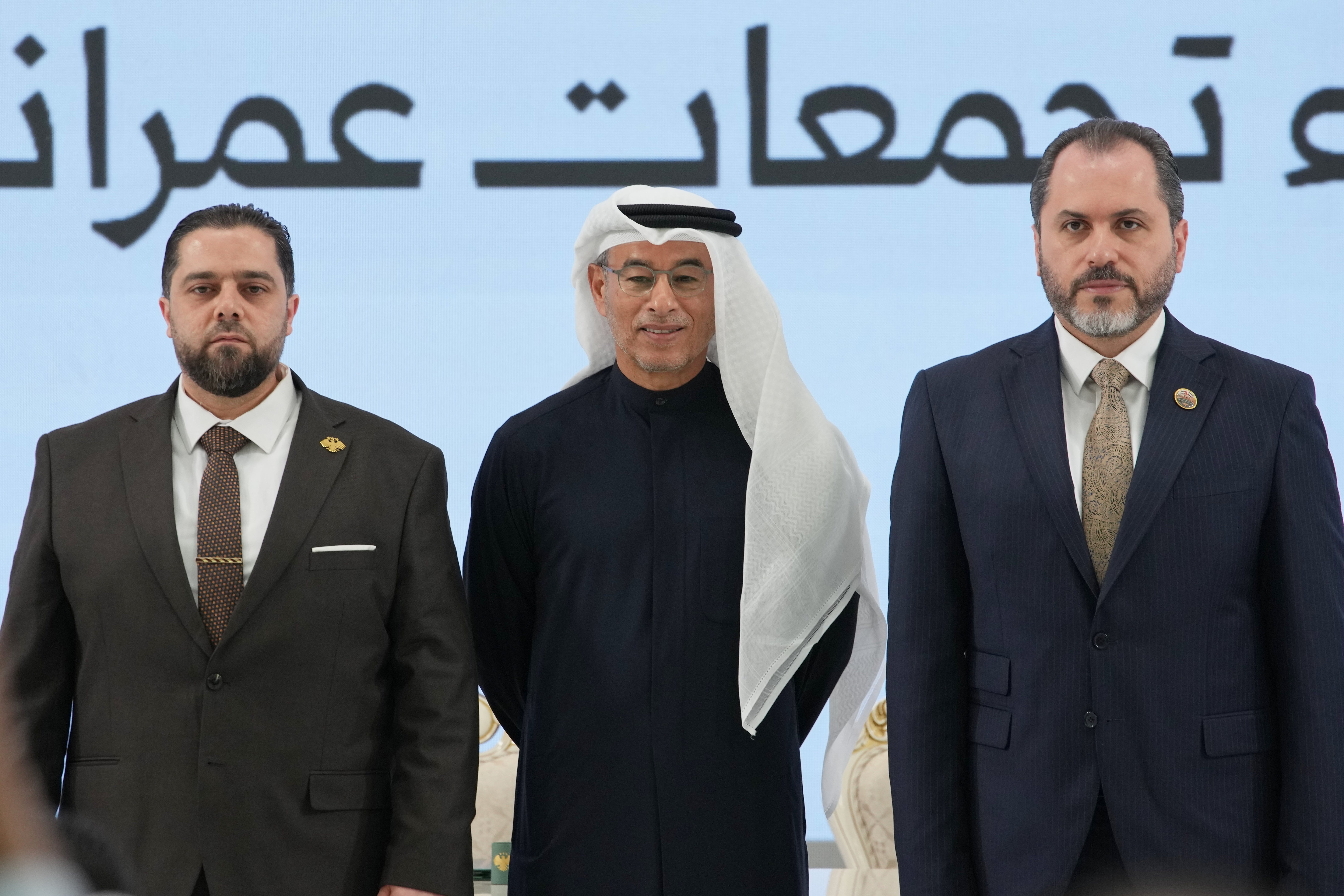 Syrian Tourism Minister Mazen al-Salhani, right, Emirati businessman Mohamed Alabbar, founder and chairman of Eagle Hills, center, and Syrian Minister of Public Works and Housing Mustafa Abdul Razzaq, left, pose for a photograph during a signing ceremony for agreements to develop urban and tourism projects in Damascus and Latakia, at the People's Palace in Damascus, Syria