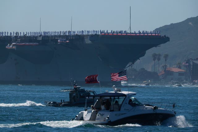Crew members stand on the deck as the USS Abraham Lincoln Nimitz-class aircraft carrier approaches its homeport at Naval Air Station North Island on return from its historic 10-month deployment on October 8