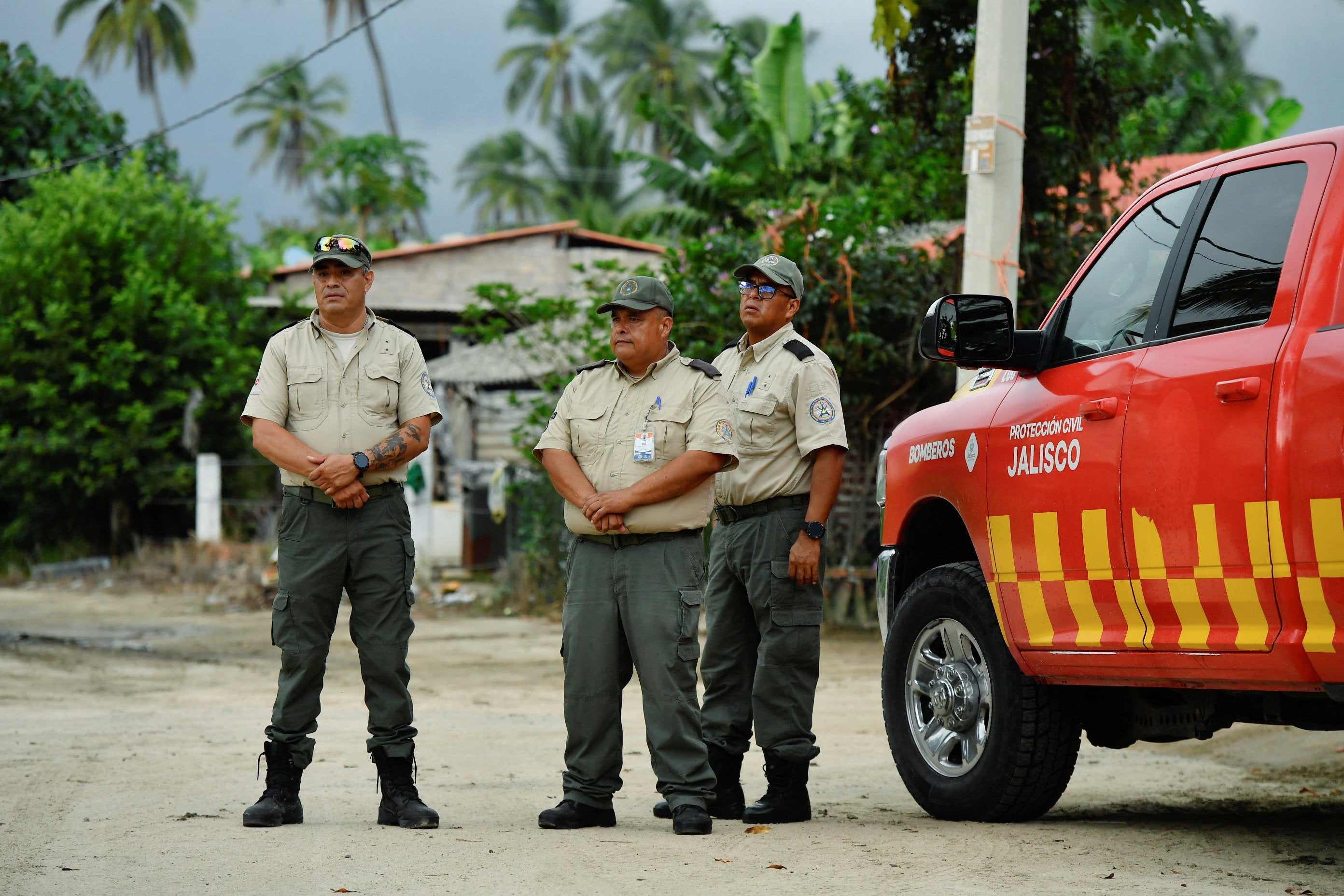 Members of the Civil Protection of Jalisco stand as they carry out a preventive evacuation of residents ahead of Tropical Storm Simon approaching Mexico's Pacific coast