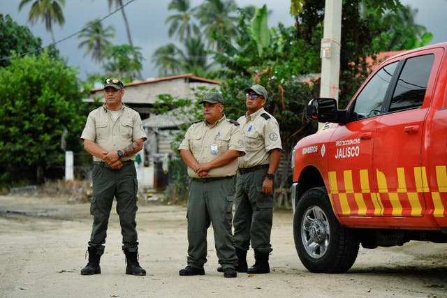 Members of the Civil Protection of Jalisco stand as they carry out a preventive evacuation of residents ahead of Tropical Storm Simon approaching Mexico's Pacific coast