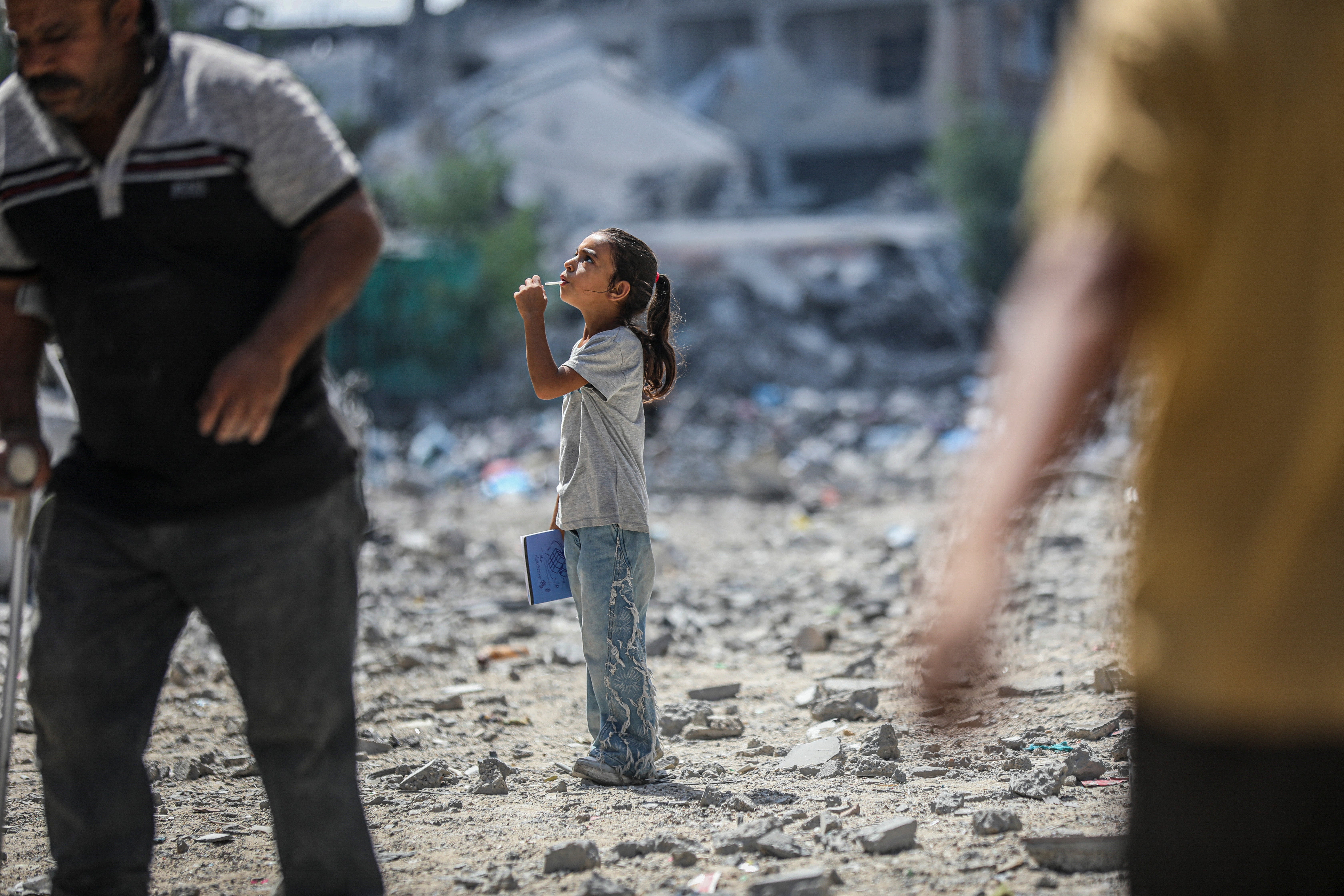 A child walks through a rubble-covered street as residents move among damaged buildings in the Al-Tuffah neighborhood of Gaza City, Gaza Strip on September 22, 2026.