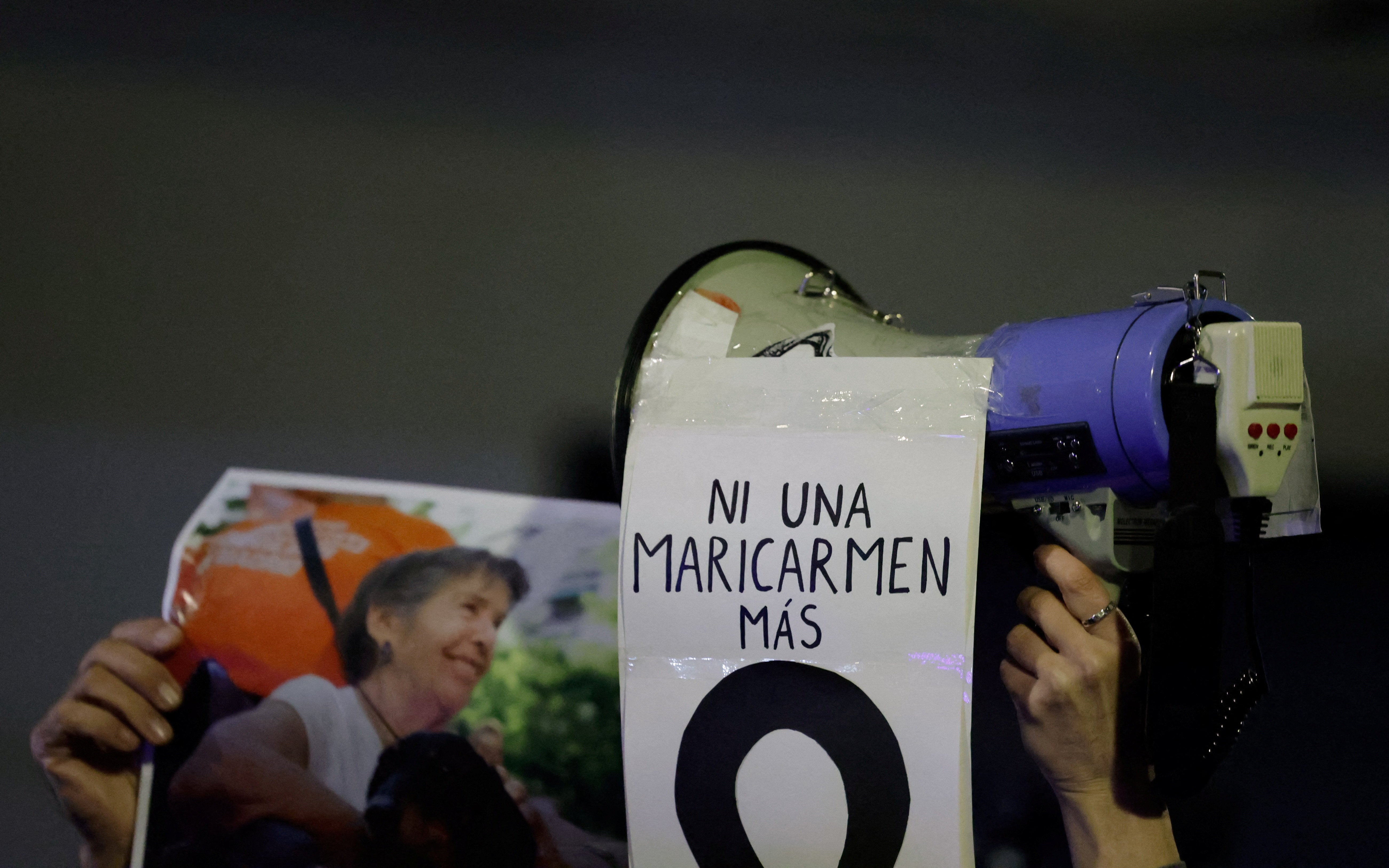 A demonstrator carries a picture of the late Maricarmen Abascal and a sign reading ‘not one Maricarmen more’, in Madrid, on Thursday