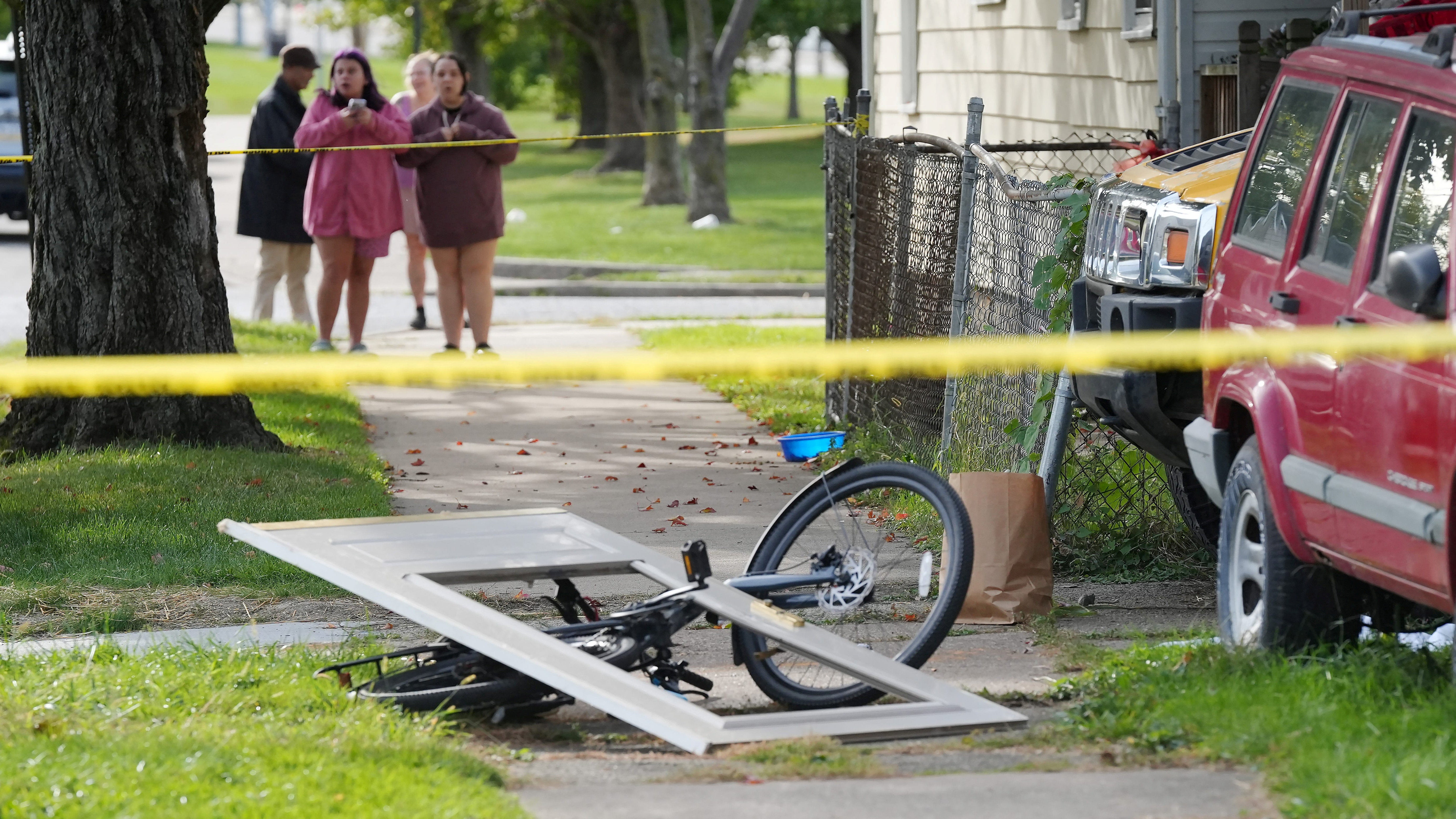 Bystanders gather Saturday near the Erie, Pennsylvania, house where nine people were confirmed dead Friday night