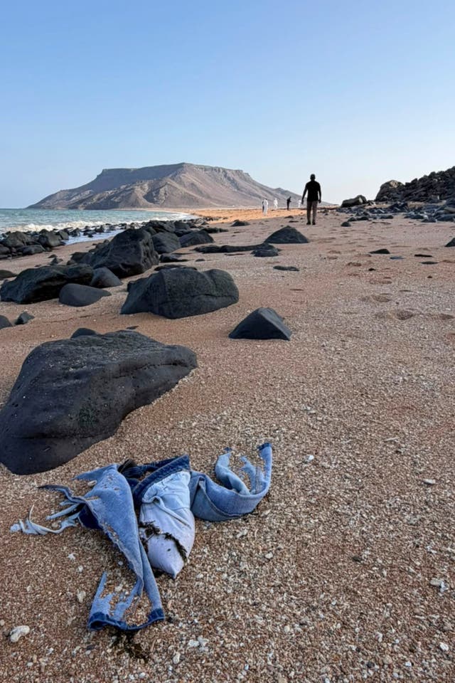 Personal items likely belonging to the migrants, including shoes, were seen on a beach in a video shared by IOM.