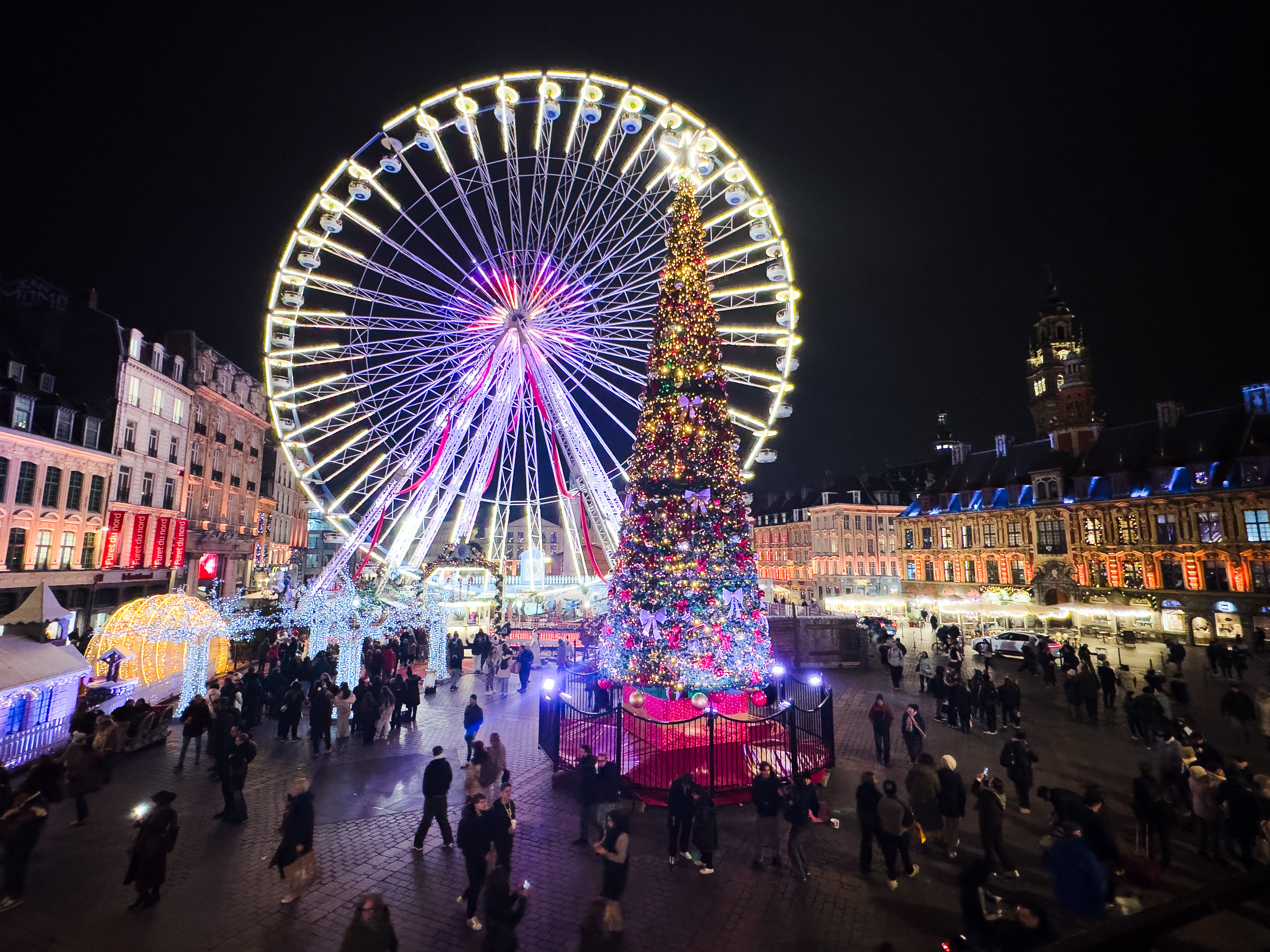 Lille Christmas market with its illuminated ferris wheel and large decorated Christmas tree on Grand Place in Lille in Hauts de France