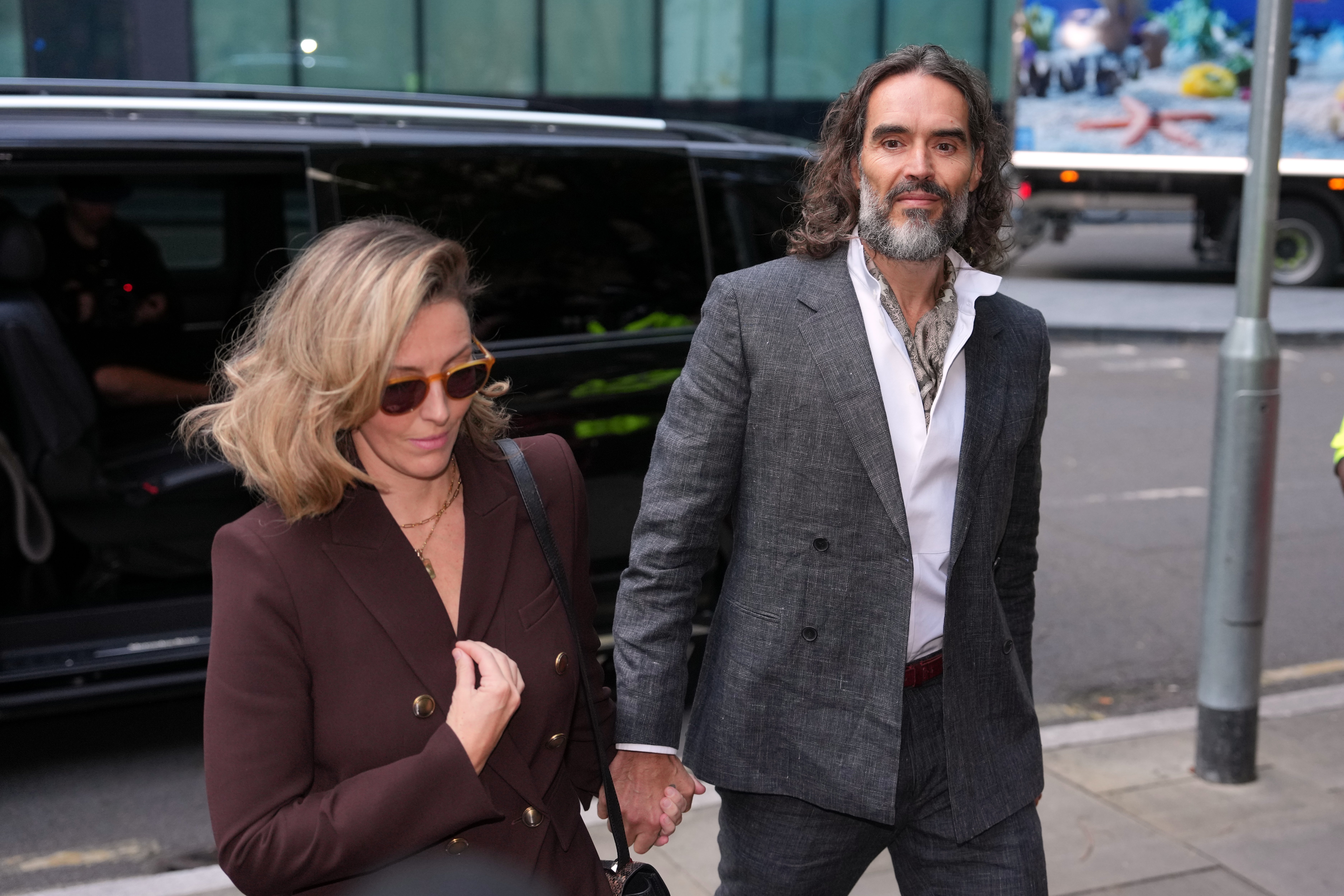 Comedian and actor Russell Brand, accompanied by his wife Laura Brand, arrives at Southwark Crown Court where he is charged with counts of rape and sexual assault against six women, which he has denied, in London, Monday, Oct. 12, 2026.(AP Photo/Kin Cheung)