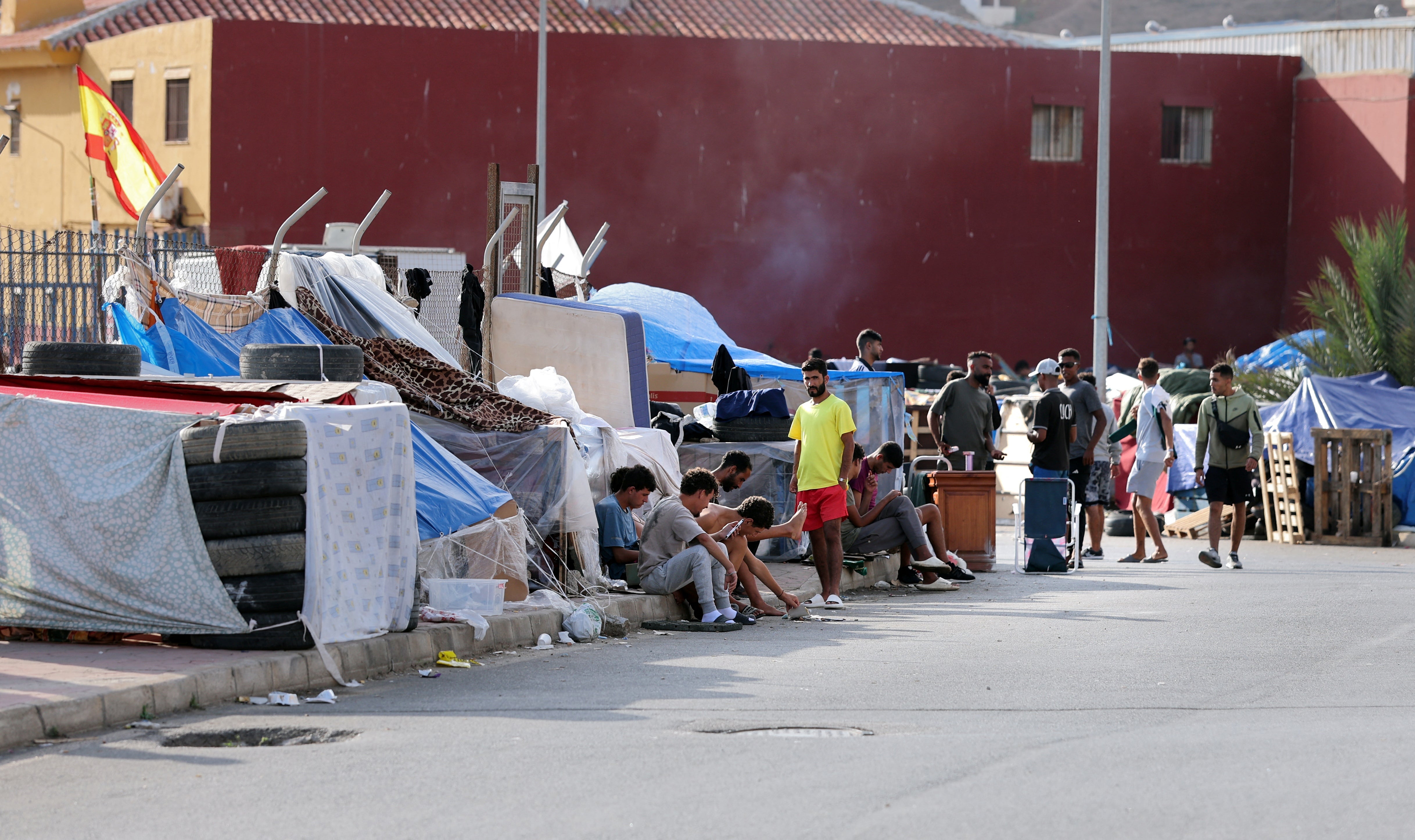 Migrants wait in a makeshift camp near the Spanish-Moroccan border in Spain's North African enclave of Ceuta.
