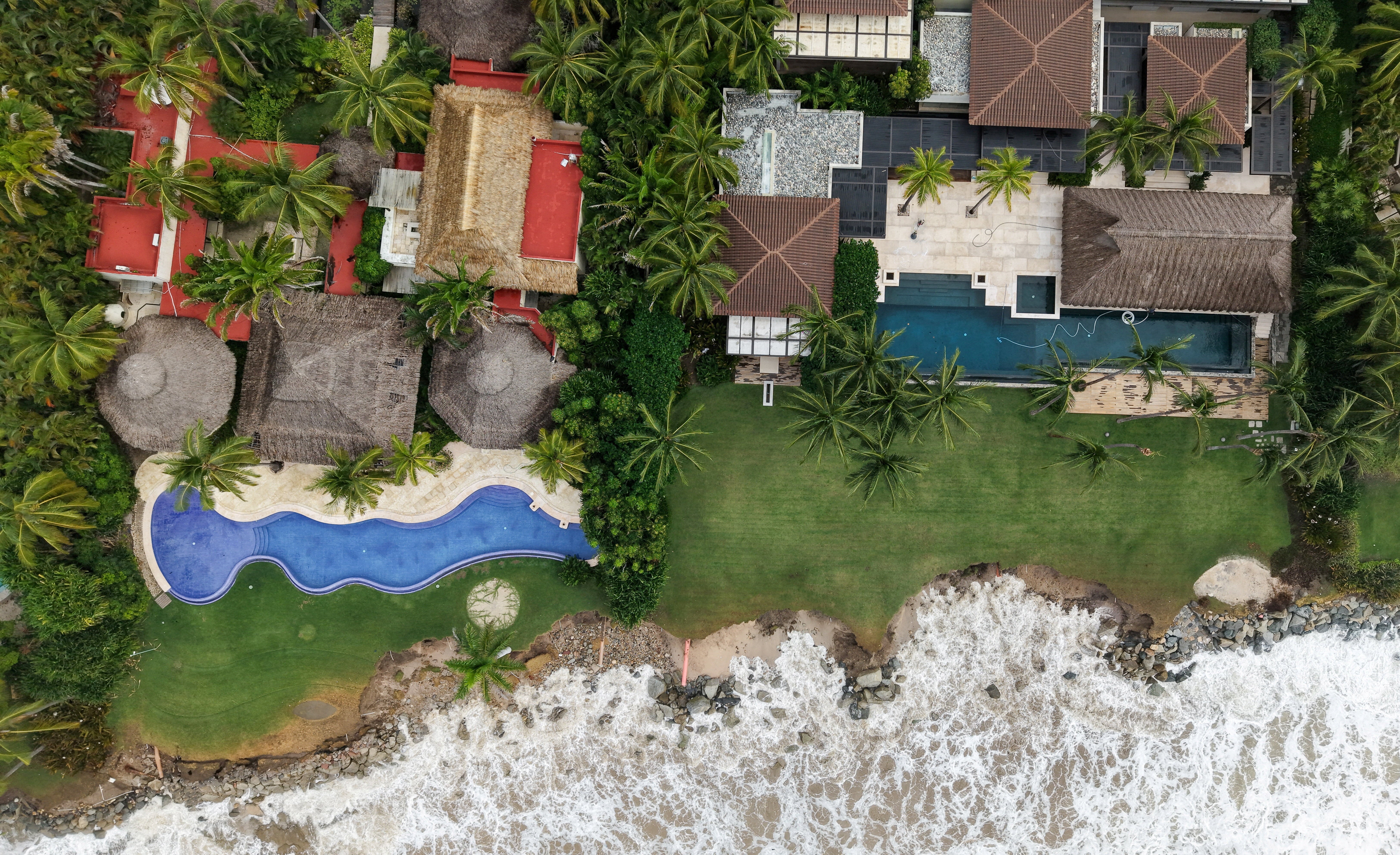 A drone view shows waves eroding the shoreline near beachfront properties in Bahia de Banderas