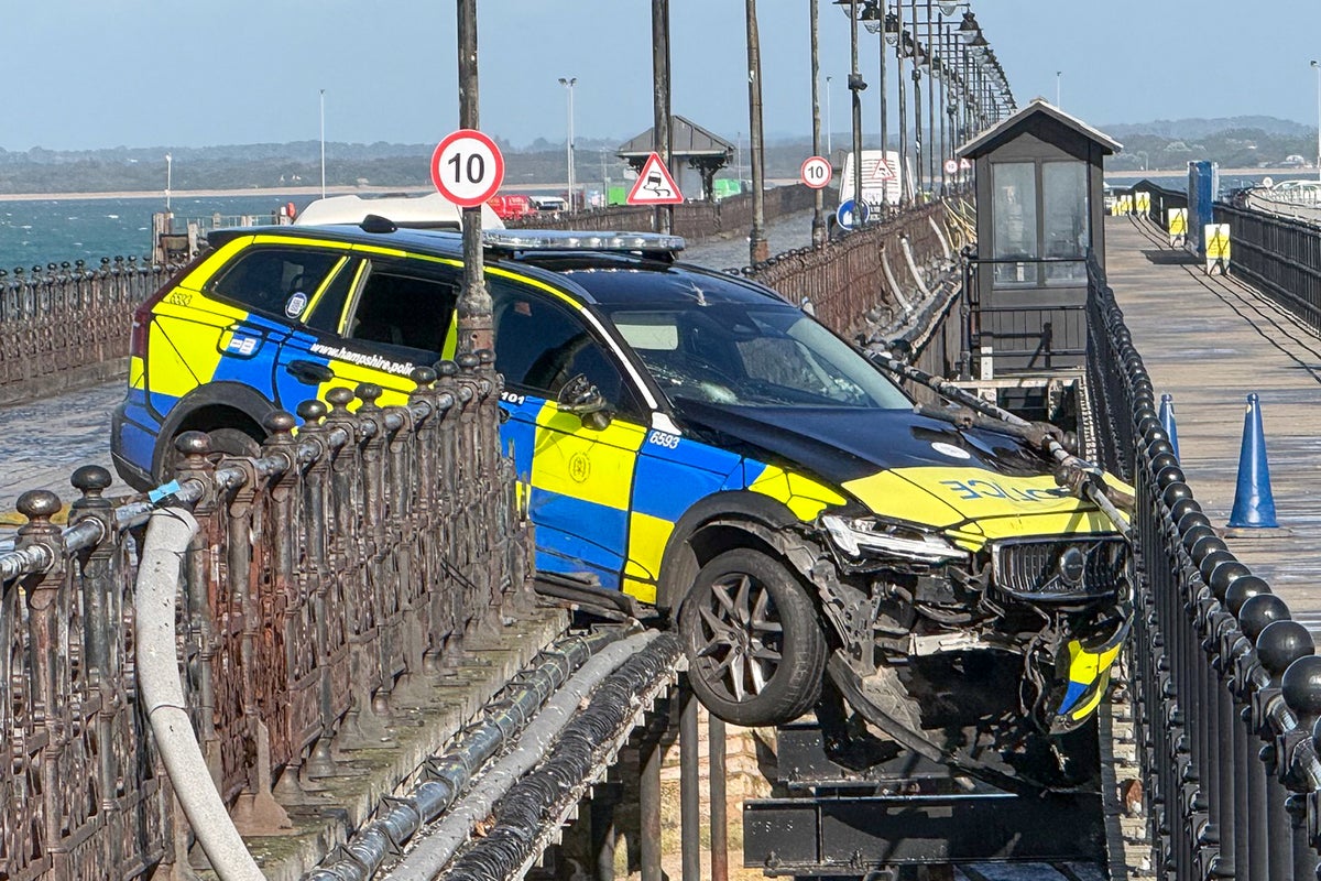 Police car left dangling mid-air after crashing through railings on UK pier
