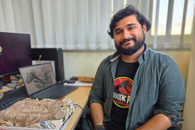 Hamzah Imrah at his desk with the fossil