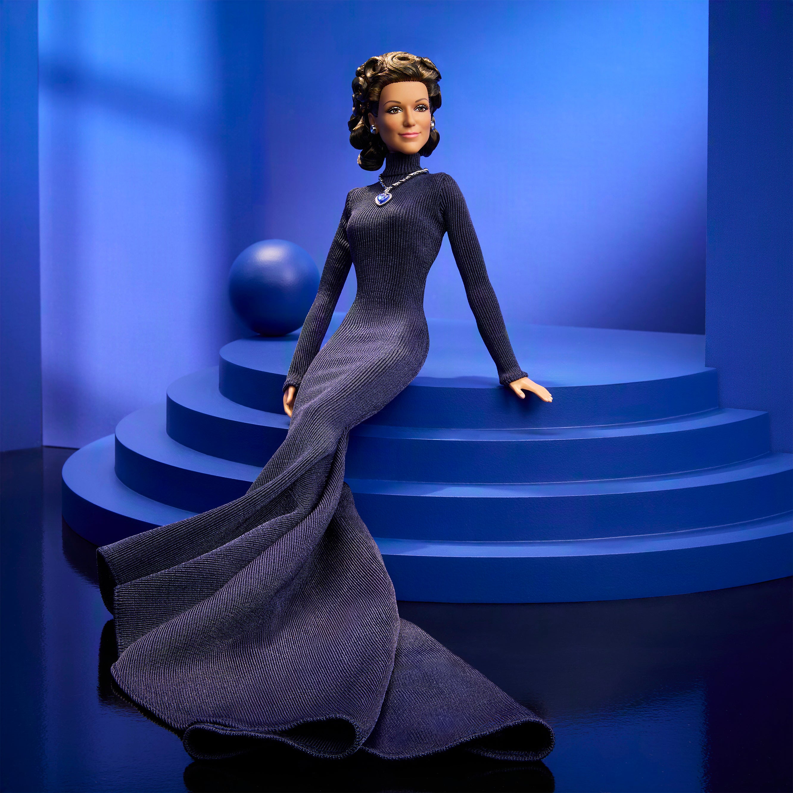 The appearance of the doll pays tribute to the navy, long-sleeved dress Dion wore when she performed Titanic theme song 'My Heart Will Go On' at the Academy Awards in 1998