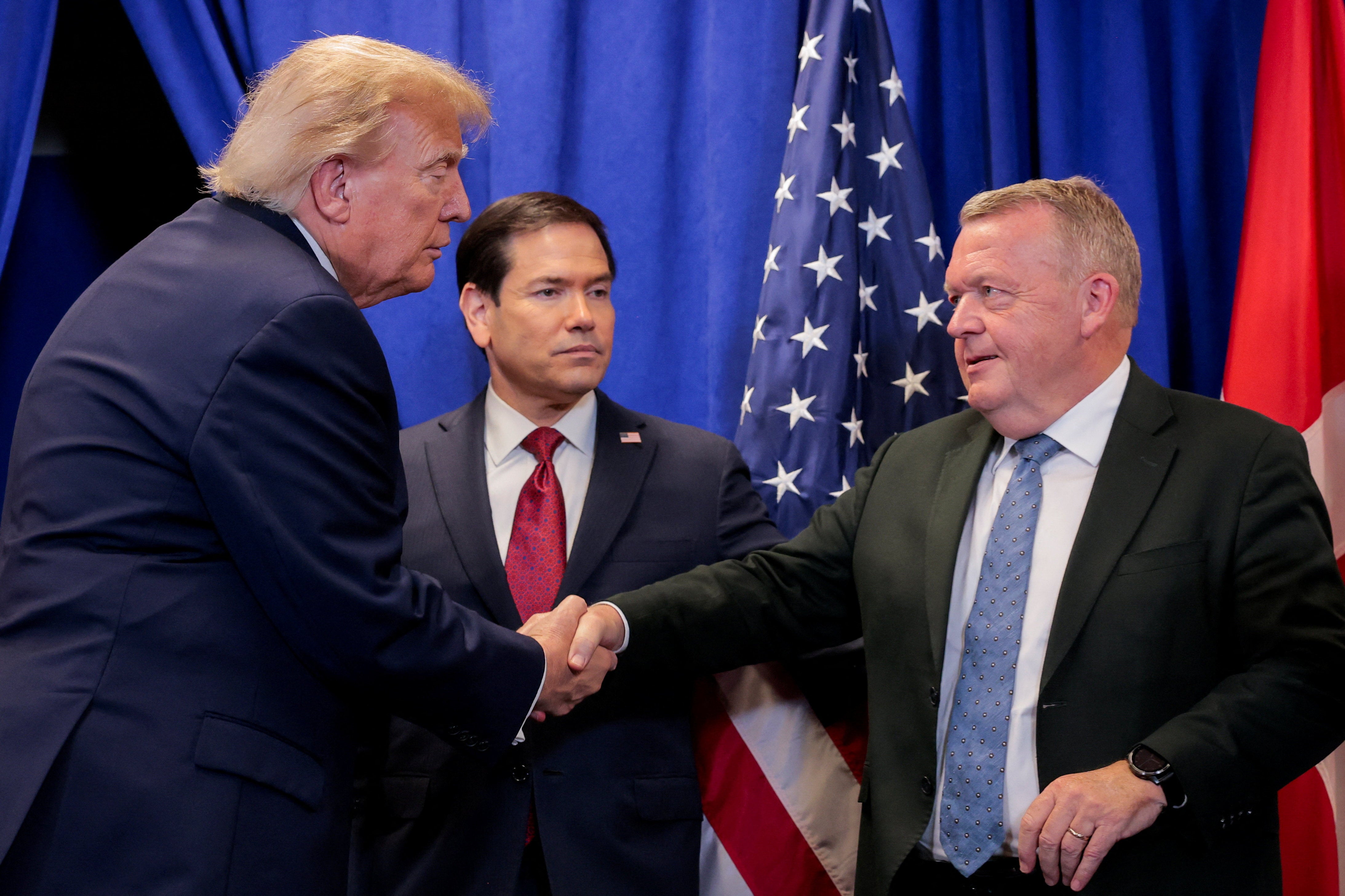 Donald Trump shake hands with Denmark's Foreign Minister Lars Loekke Rasmussen, while US Secretary of State Marco Rubio looks on, during a trilateral signing event in September