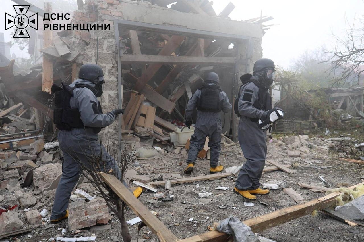 Members of the emergency services work at private houses damaged by a Russian drone strike in Rivne