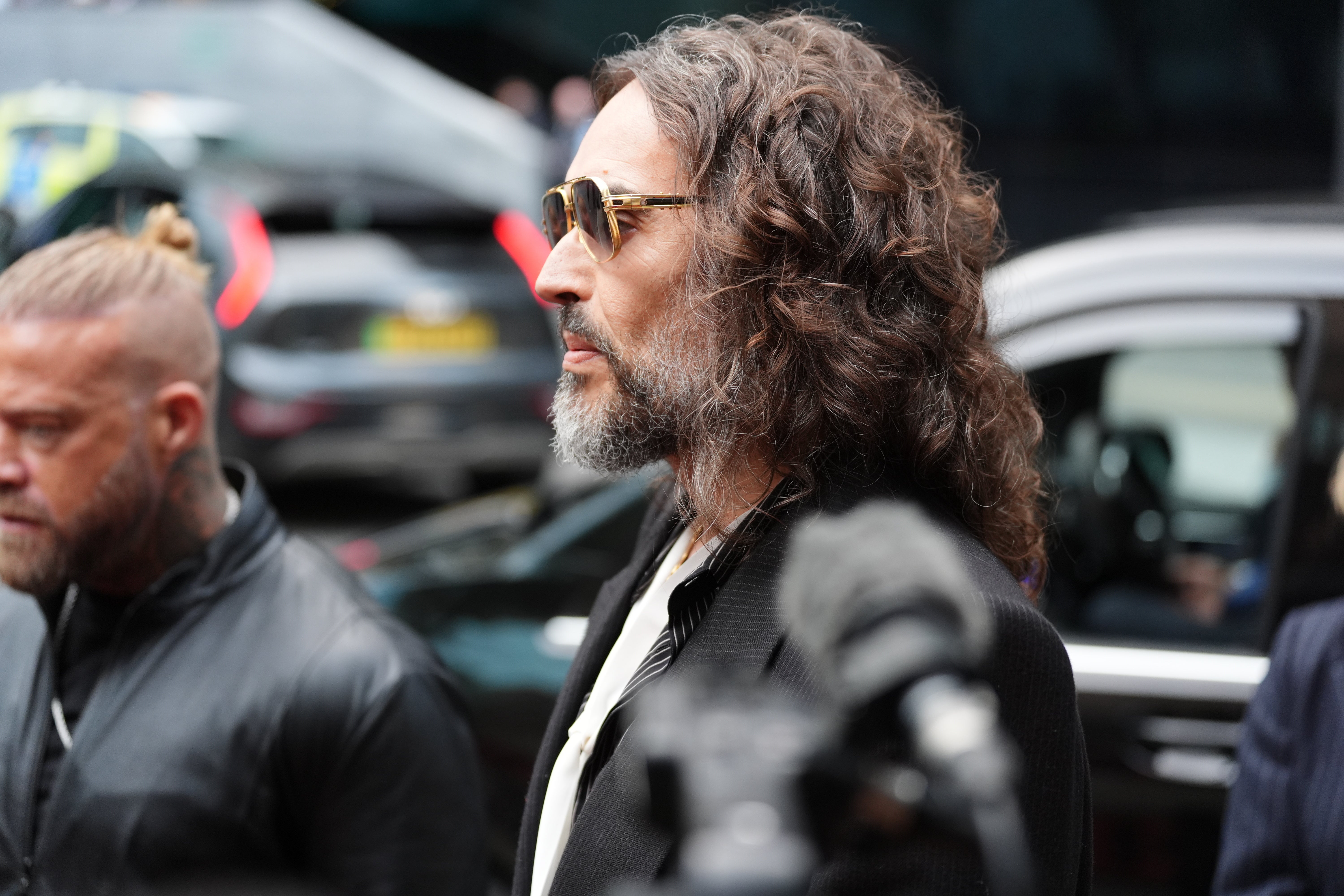 Russell Brand speaks to the media as he arrives at Southwark Crown Court (Ben Whitley/PA)