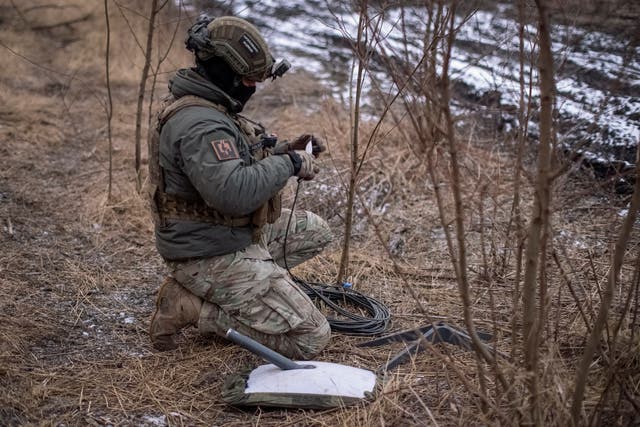 A Ukrainian serviceman of 47th brigade prepares a Starlink satellite internet system near Avdiivka, in 2024
