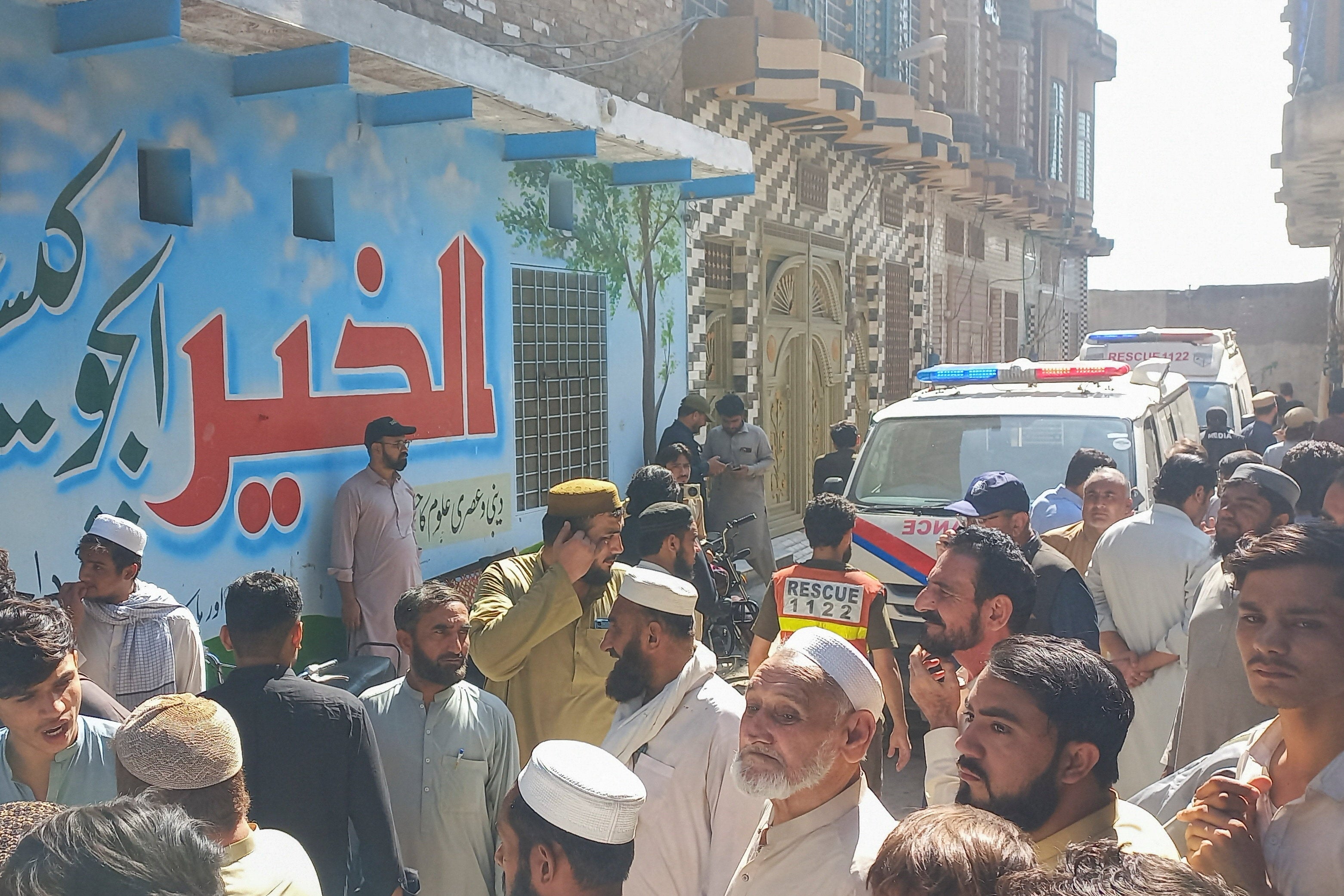 Parents and residents gather near an ambulance after a school roof collapse in Peshawar, Pakistan