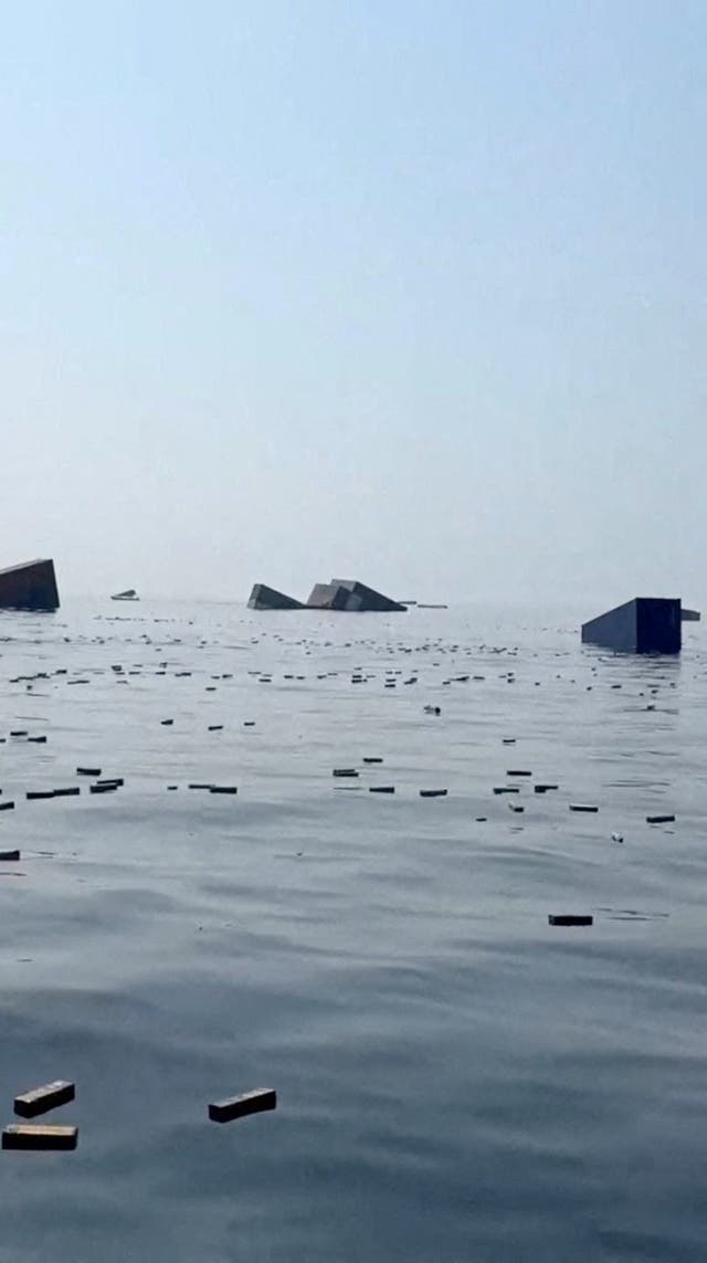 Containers and items float in the water a vessel sank near the Strait of Hormuz off the coast of Oman, in this still image obtained from a social media video, released October 14,