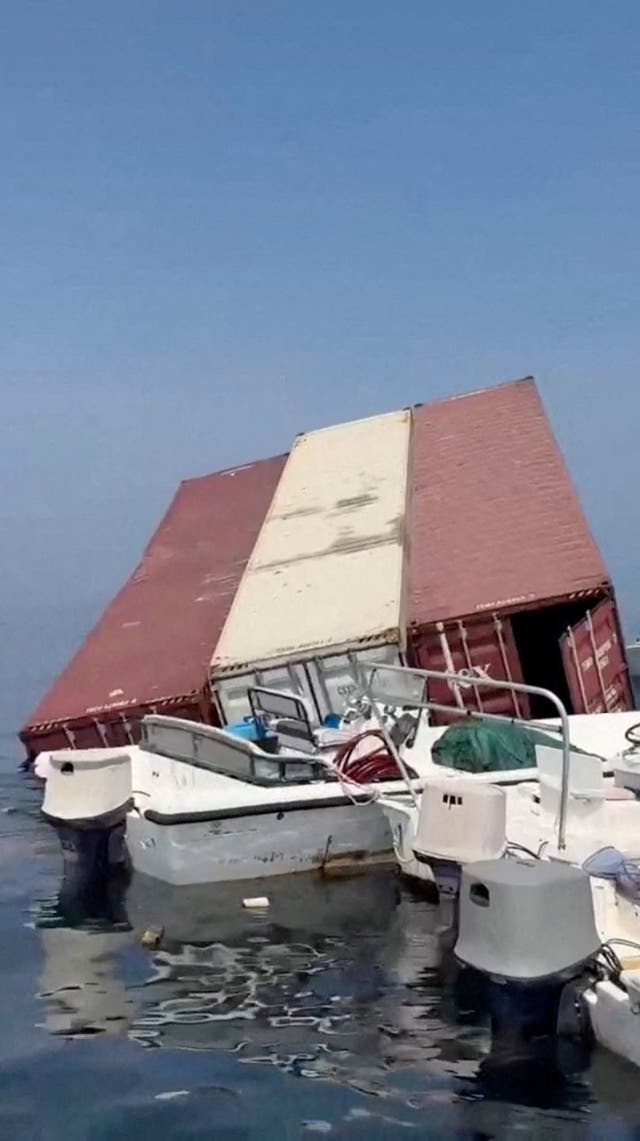 A container floats in the water a vessel sank near the Strait of Hormuz off the coast of Oman, in this still image obtained from a social media video, released October 14, 2026.